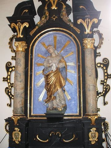 Baroque sculpture of the Madonna of Sorrows in a richly decorated altar.