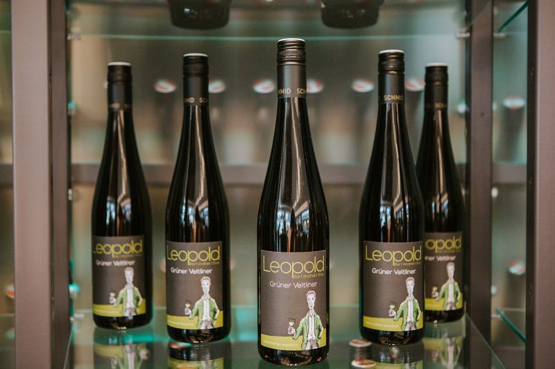 Five bottles of Grüne Veltliner wine from the Leopold brand on a shelf.