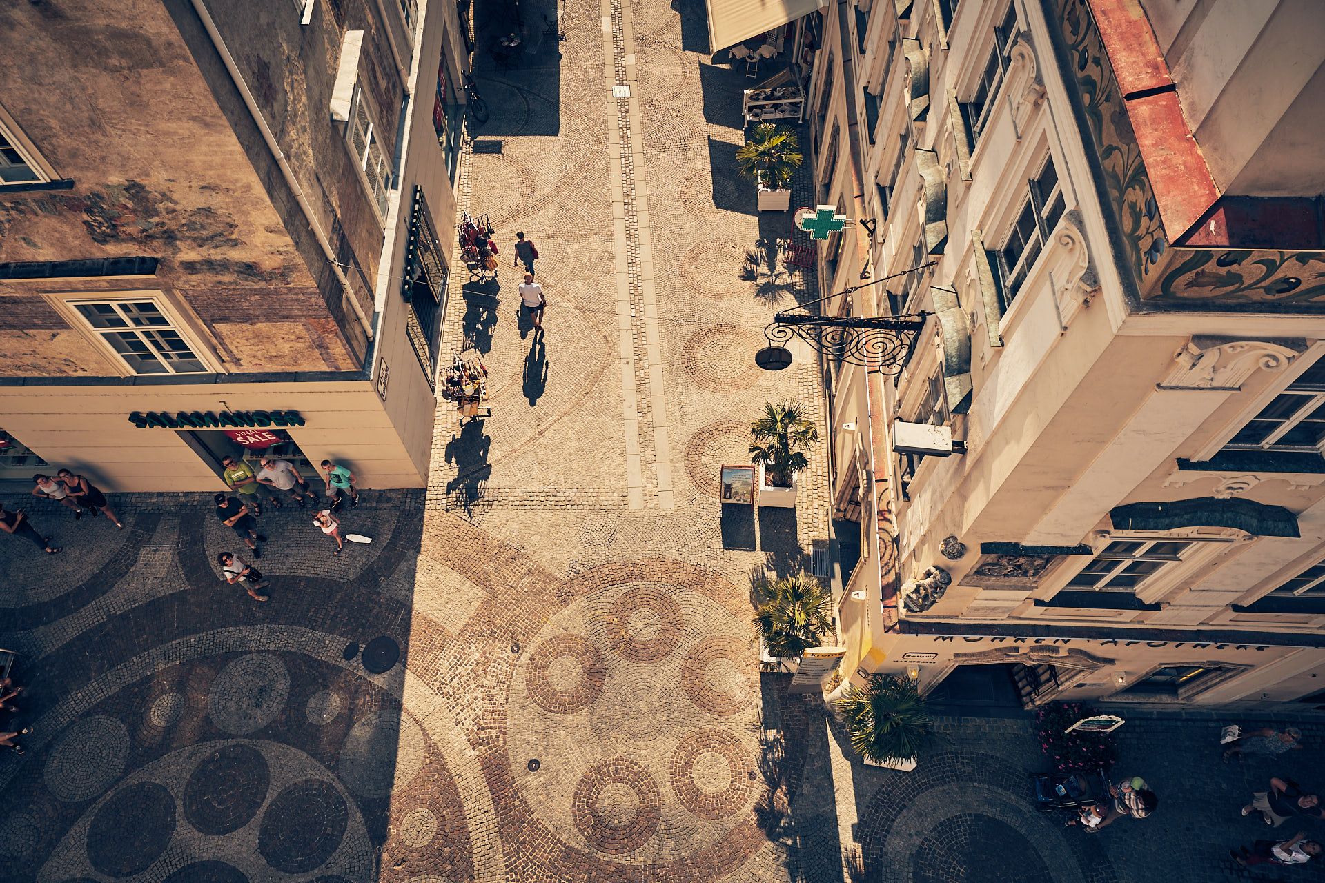 Aerial view of a cobbled street in the old town of Krems with people and stores.
