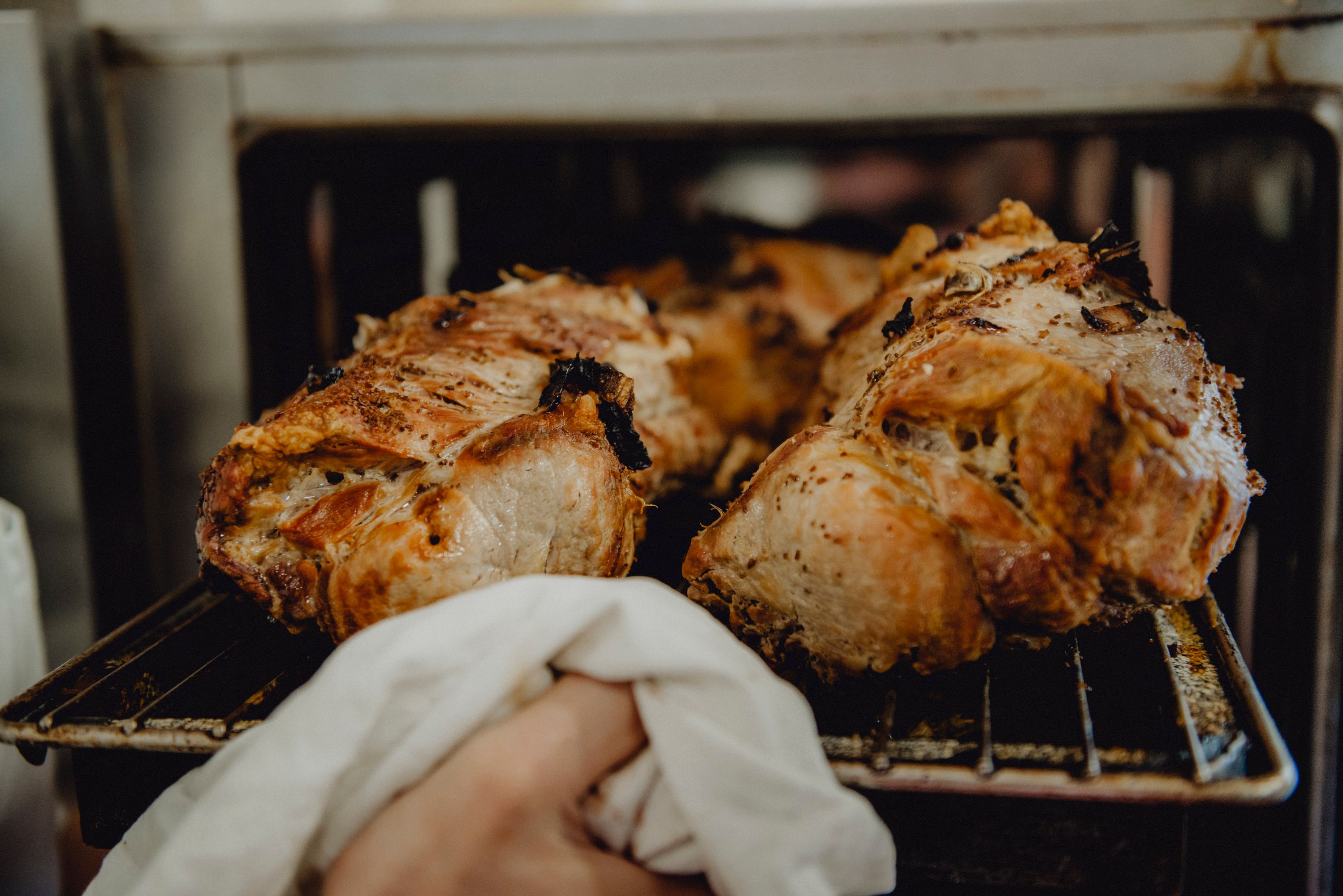 Freshly roasted pork is taken out of the oven.