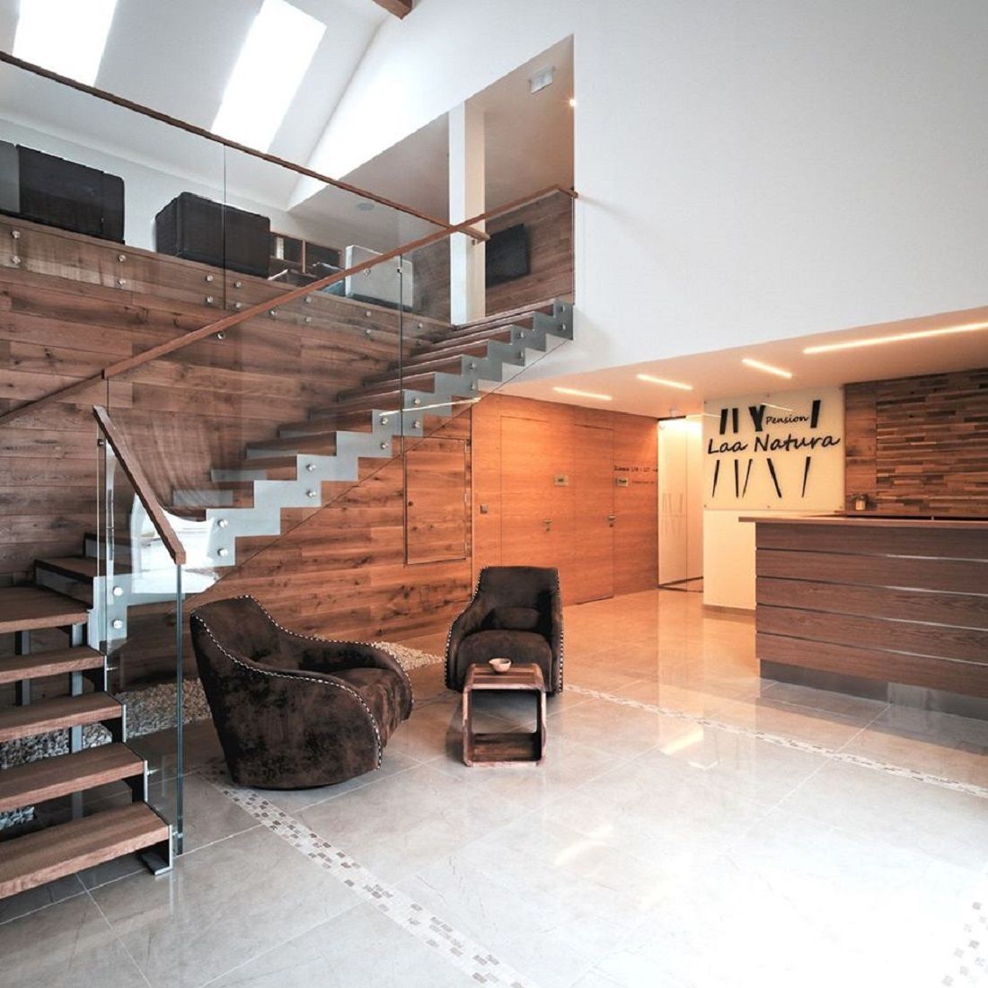 Modern entrance area with wood paneling, staircase and reception.