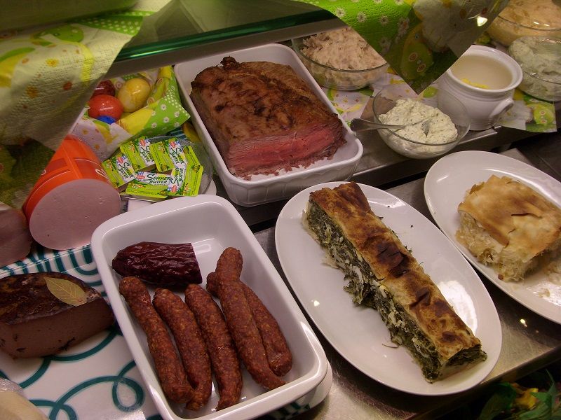 Various dishes on a buffet, including meat, sausages and strudel.