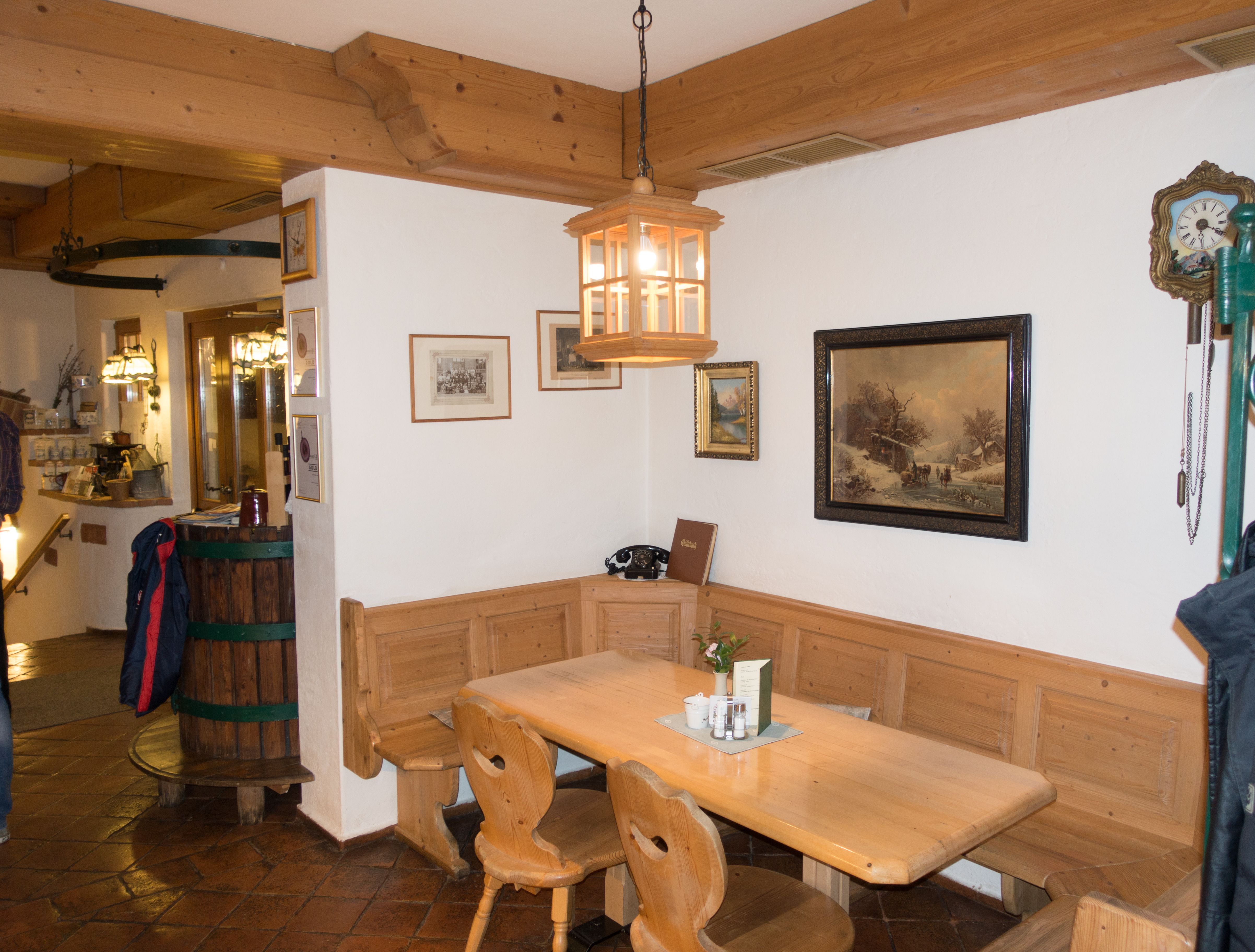 Cozy wooden corner in a traditional inn with table, chairs and wall decorations.