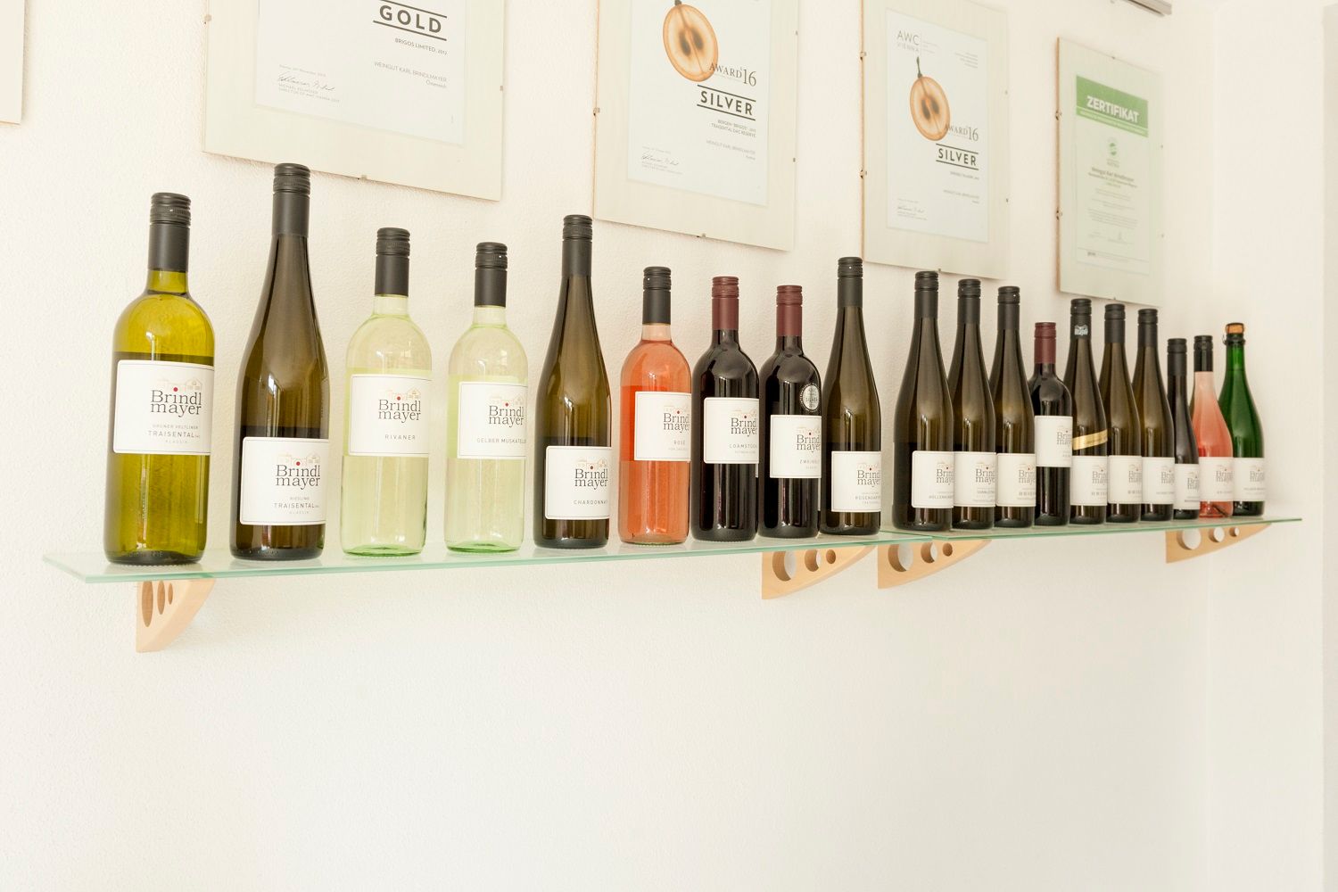 Shelf with Brindlmayer wine bottles and awards on the wall.