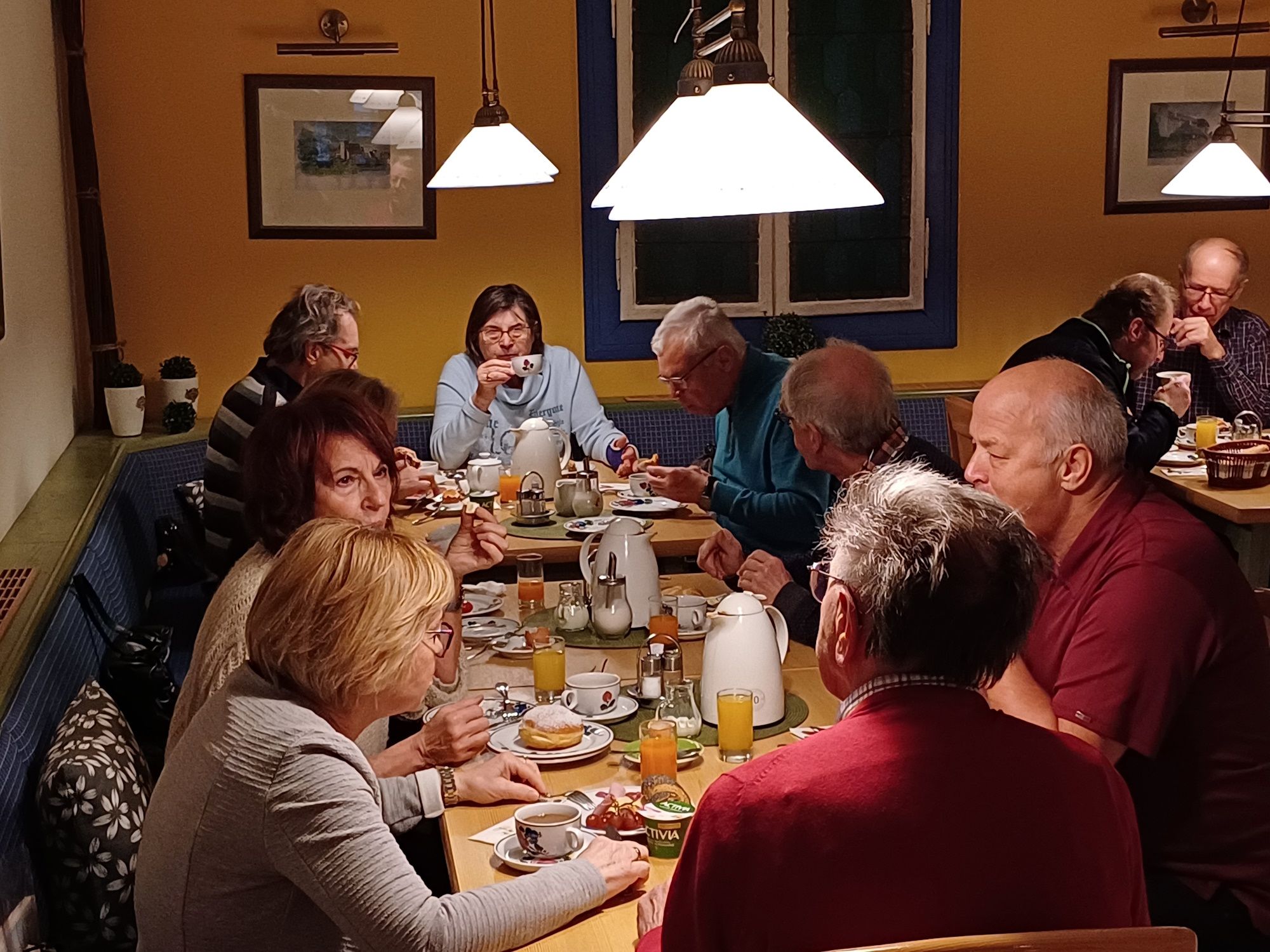 Group of people having breakfast in a cozy room.