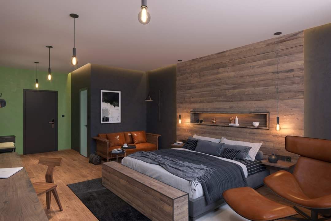 Modern bedroom with wooden wall, large bed, leather sofa and stylish lamps.