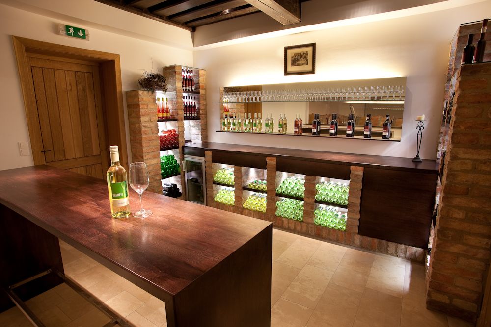 Interior view of a stylish wine shop with wine bottles and glasses on shelves.