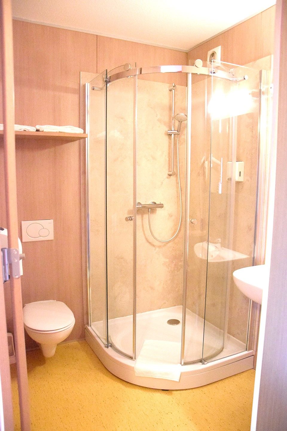 Small bathroom with shower, toilet and washbasin.