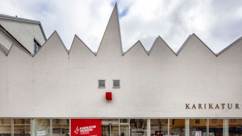 Facade of the Caricature Museum Krems with jagged roof and red square.