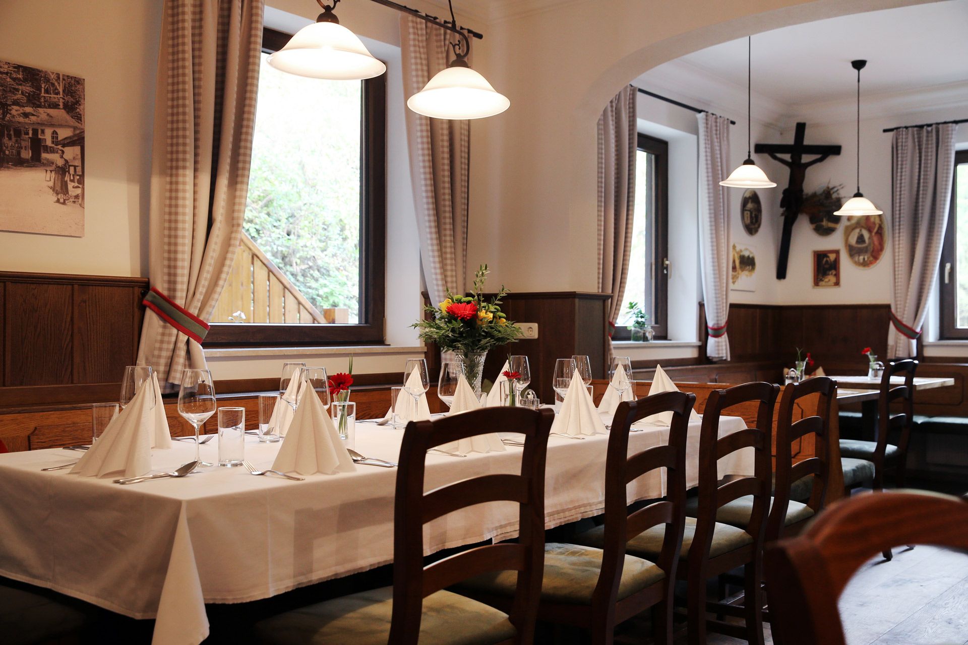 Interior of a cozy inn with a set table, wooden furniture and decorations on the walls.