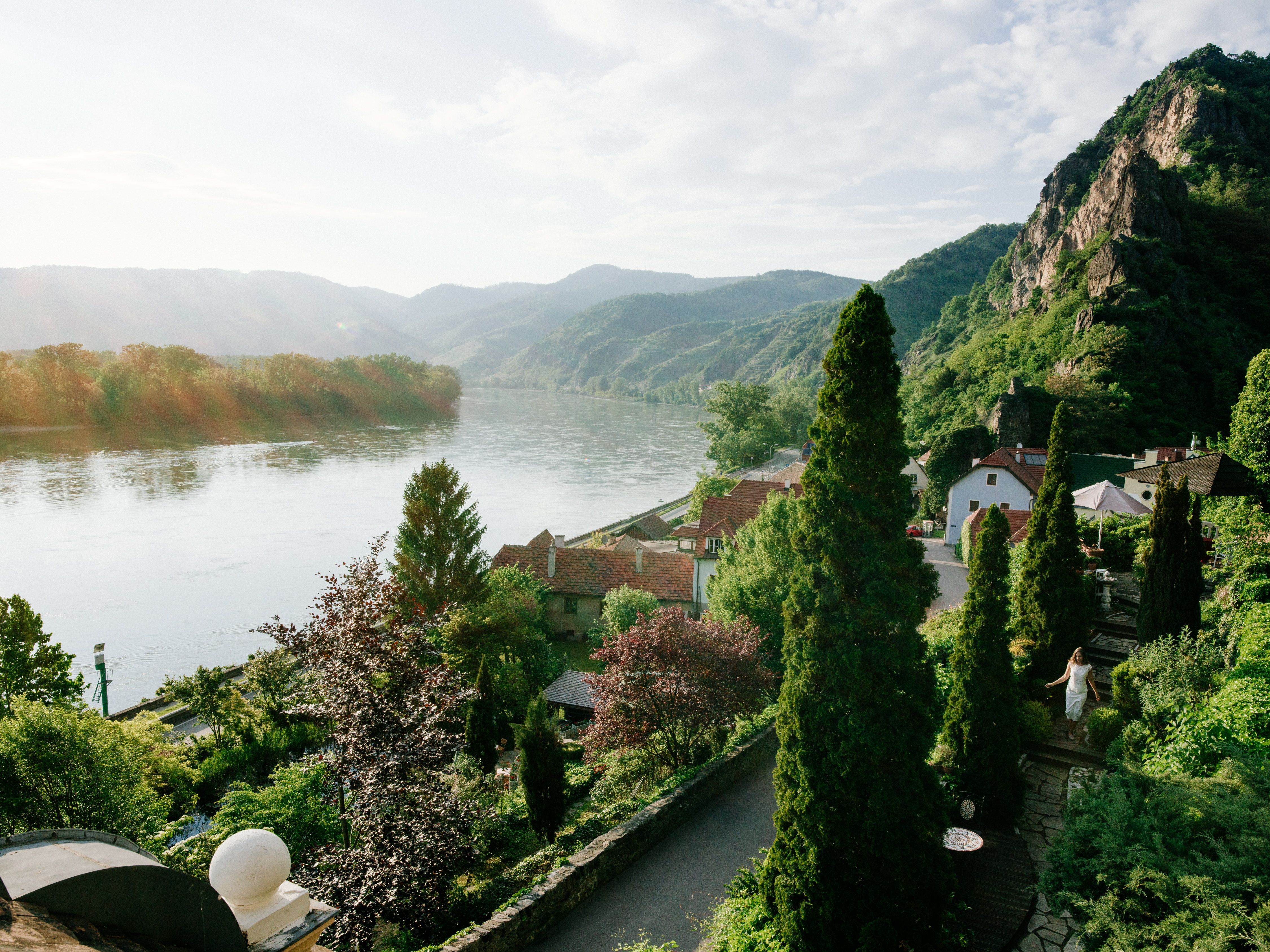 View of river landscape with mountains and houses.