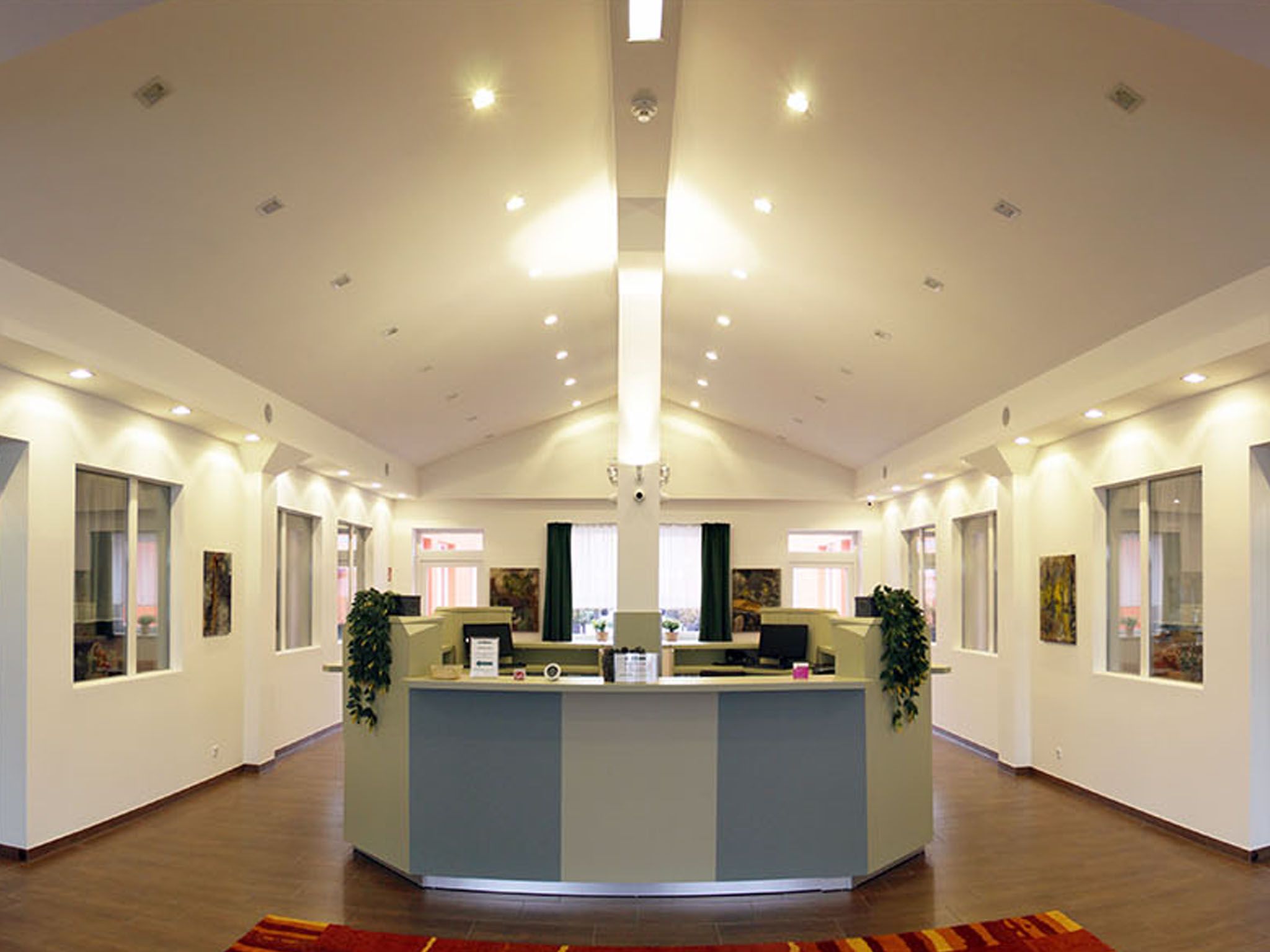 Modern reception office with desk and plants.