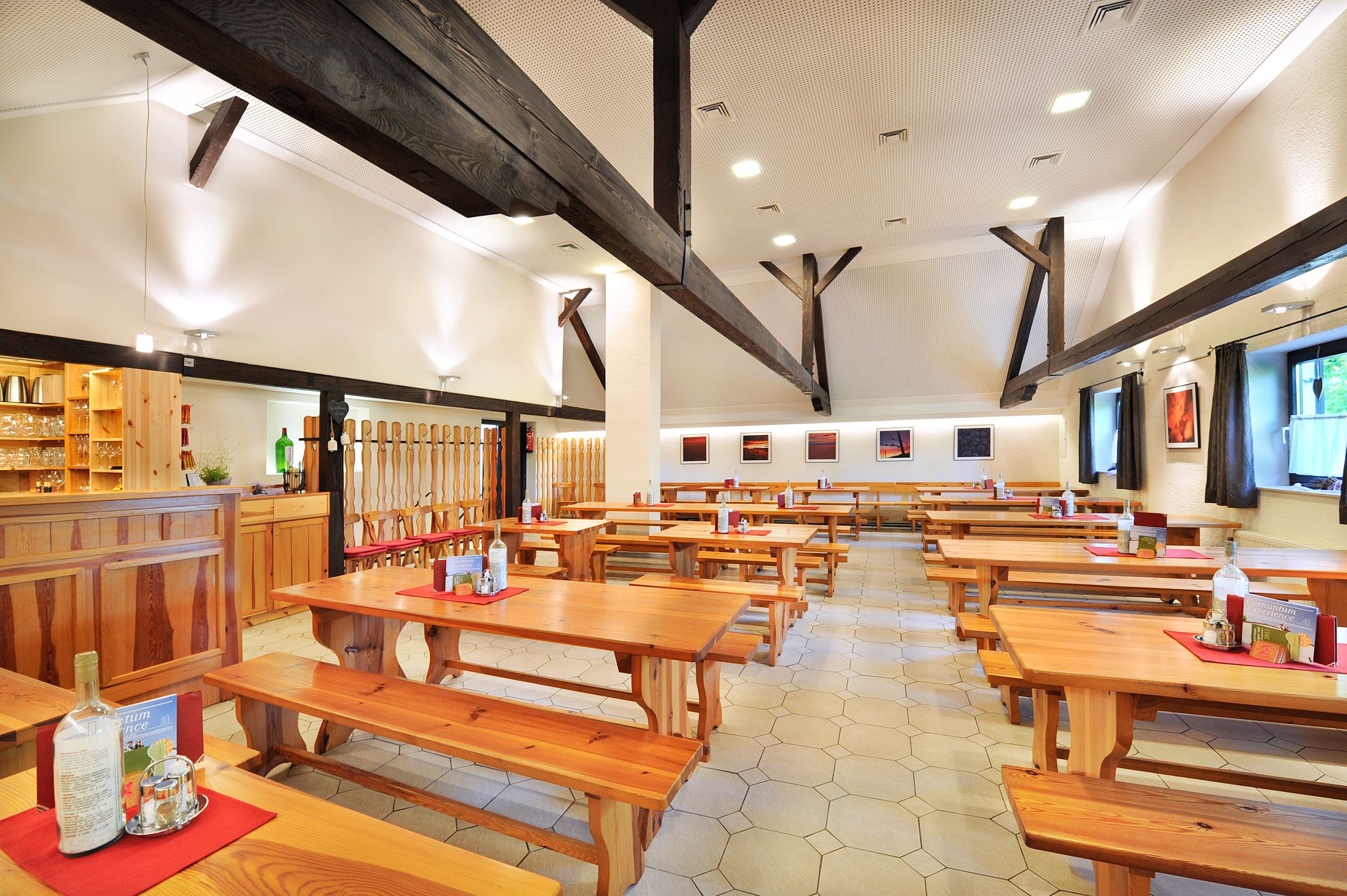 Interior view of a winery with wooden tables and benches.