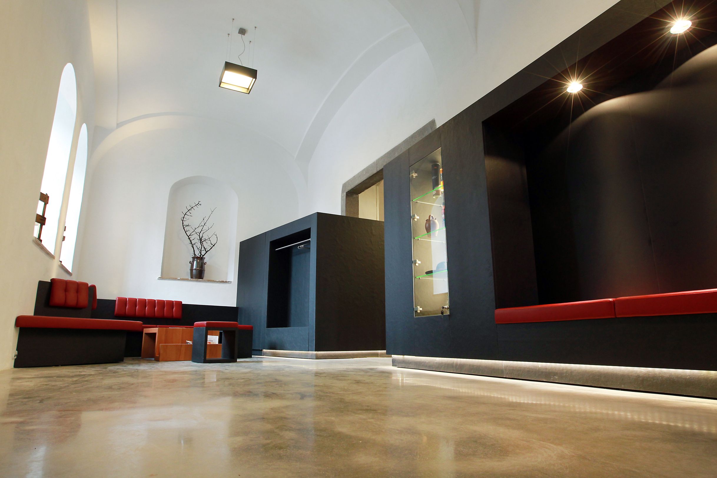 Modern interior with red benches and black walls.