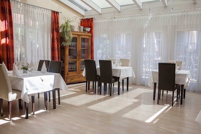 Interior view of a bright restaurant with set tables and chairs.