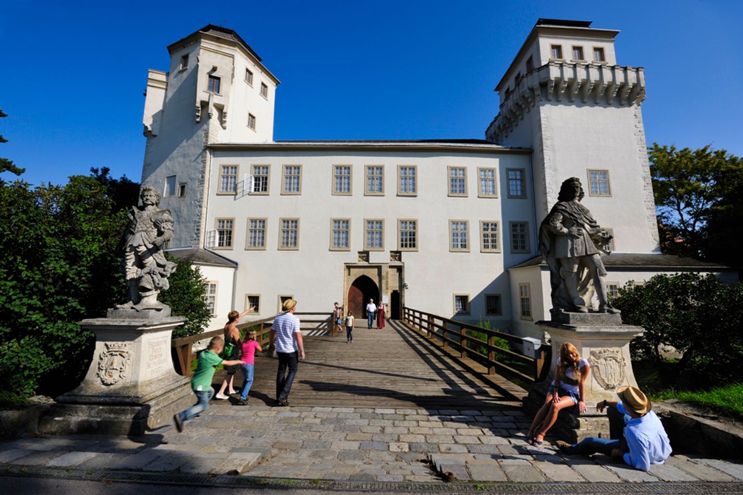 Asparn/Zaya Castle with visitors and statues in the foreground.