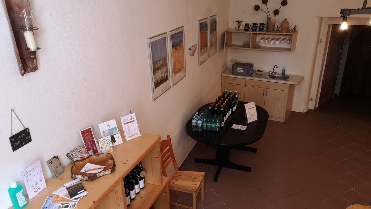Interior view of a rustic cellar with self-service counter and drinks.