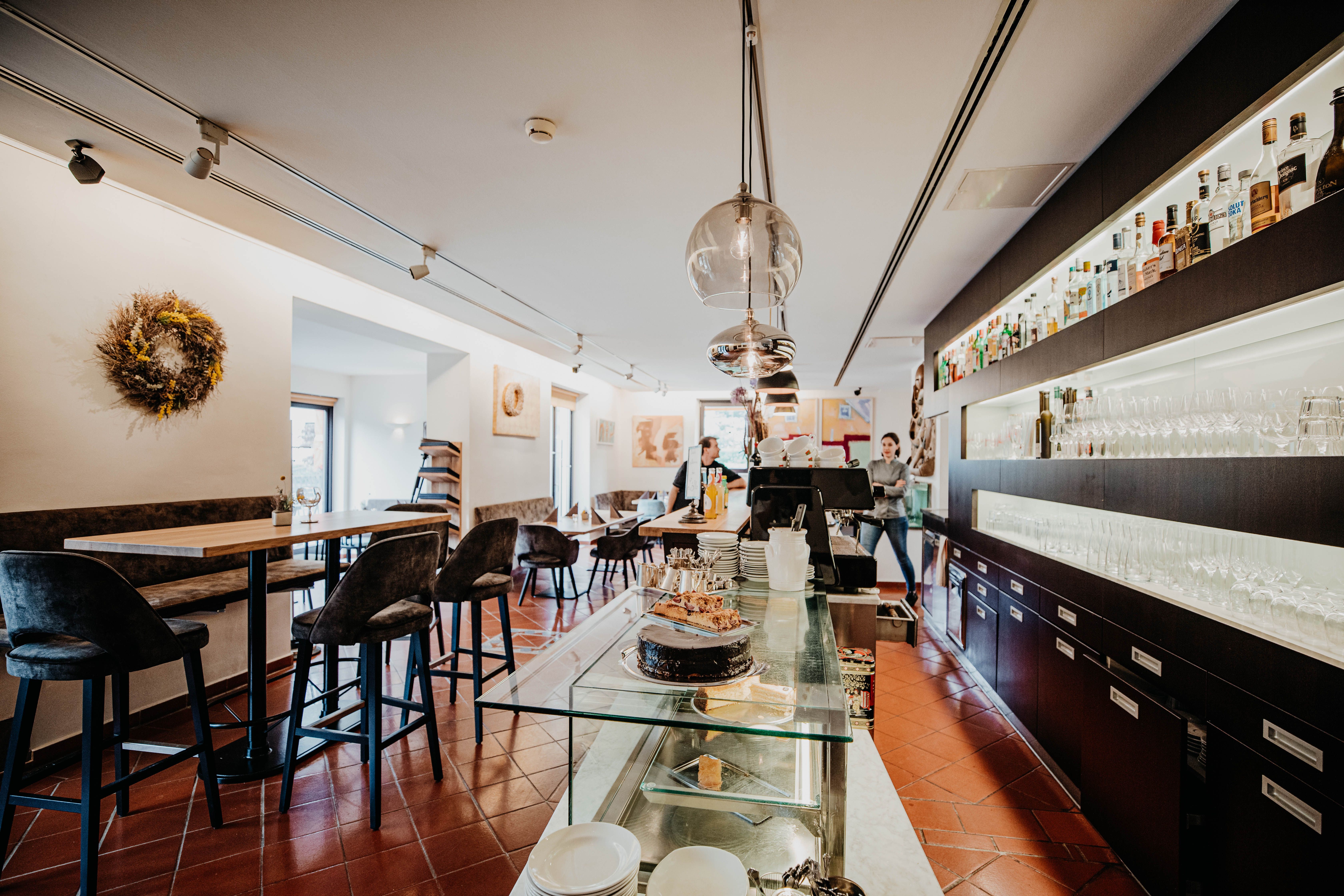 Interior view of a modern restaurant with bar, tables and chairs.