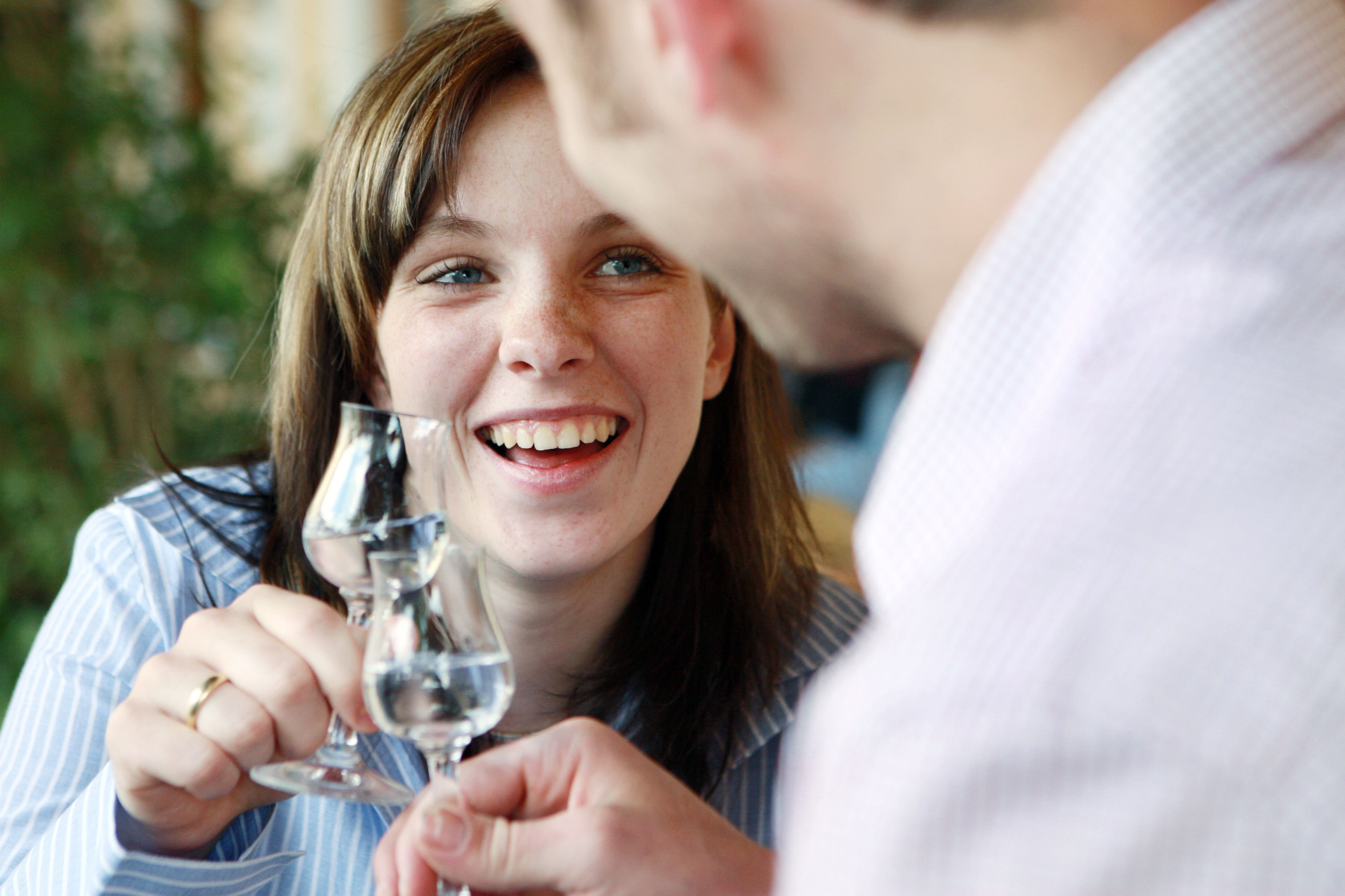 Two people clink glasses and smile.