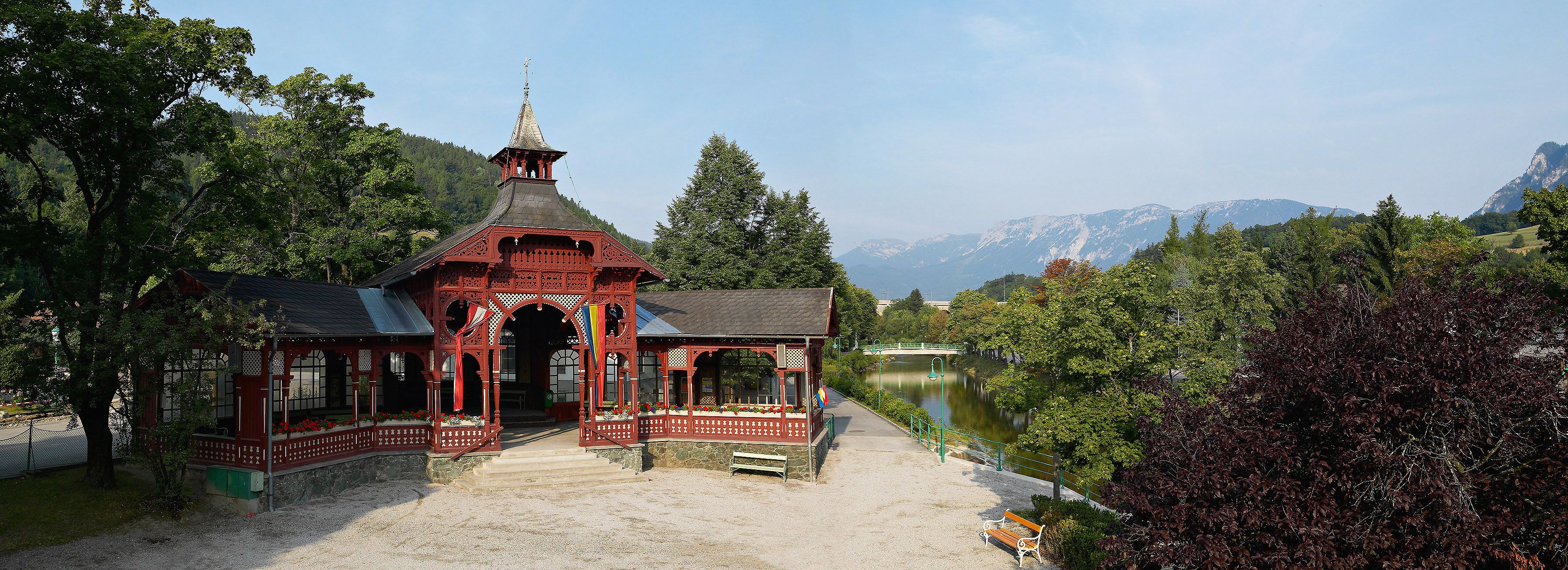 A red pavilion in Payerbach with mountains in the background.