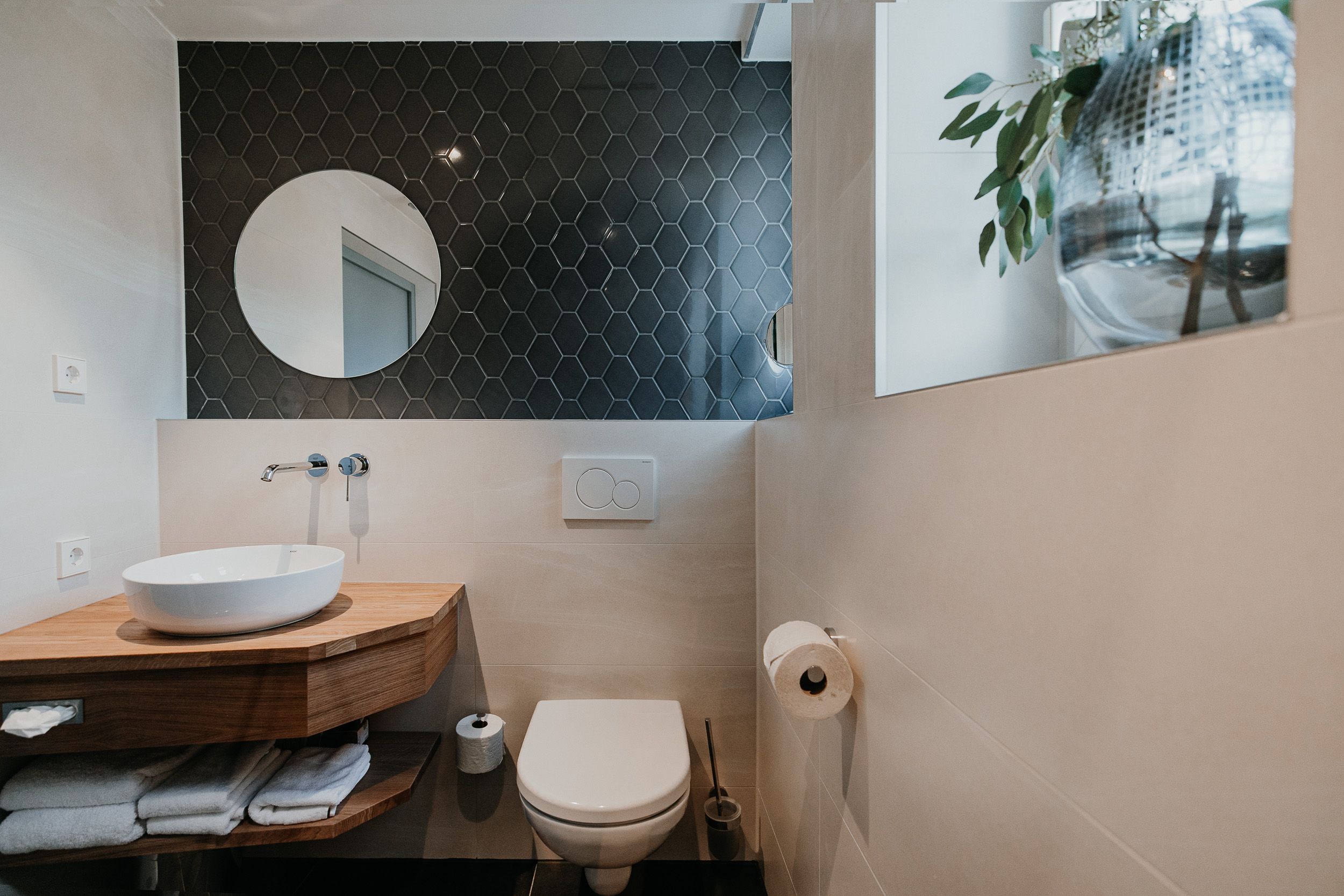 Modern bathroom with washbasin, mirror and toilet.