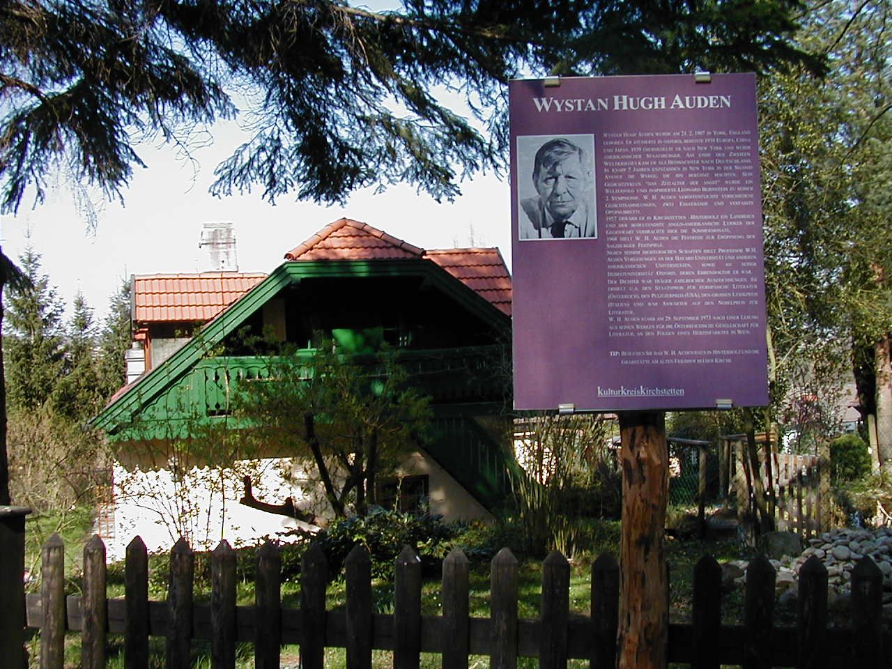 W.H. Auden memorial with information board in front of a house.