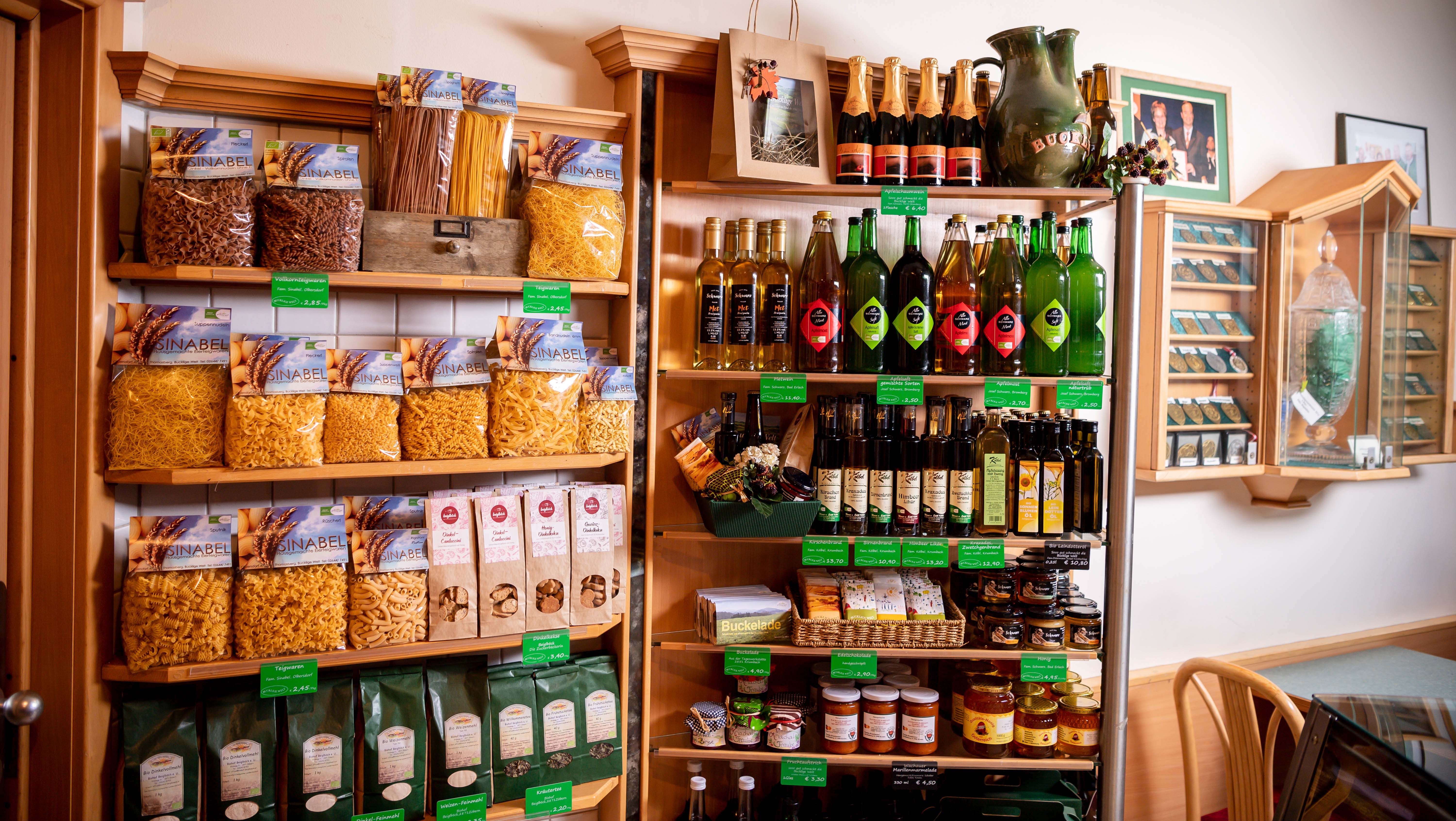 Shelf with regional foods such as pasta, oils and juices.