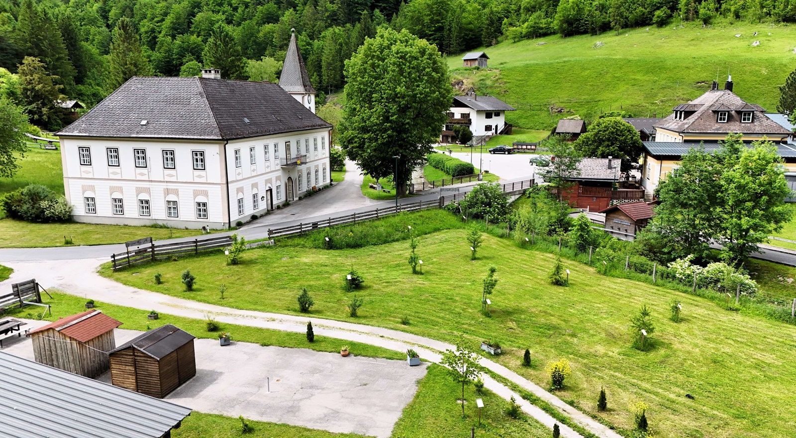 Landscape with historic building, green meadows and trees.