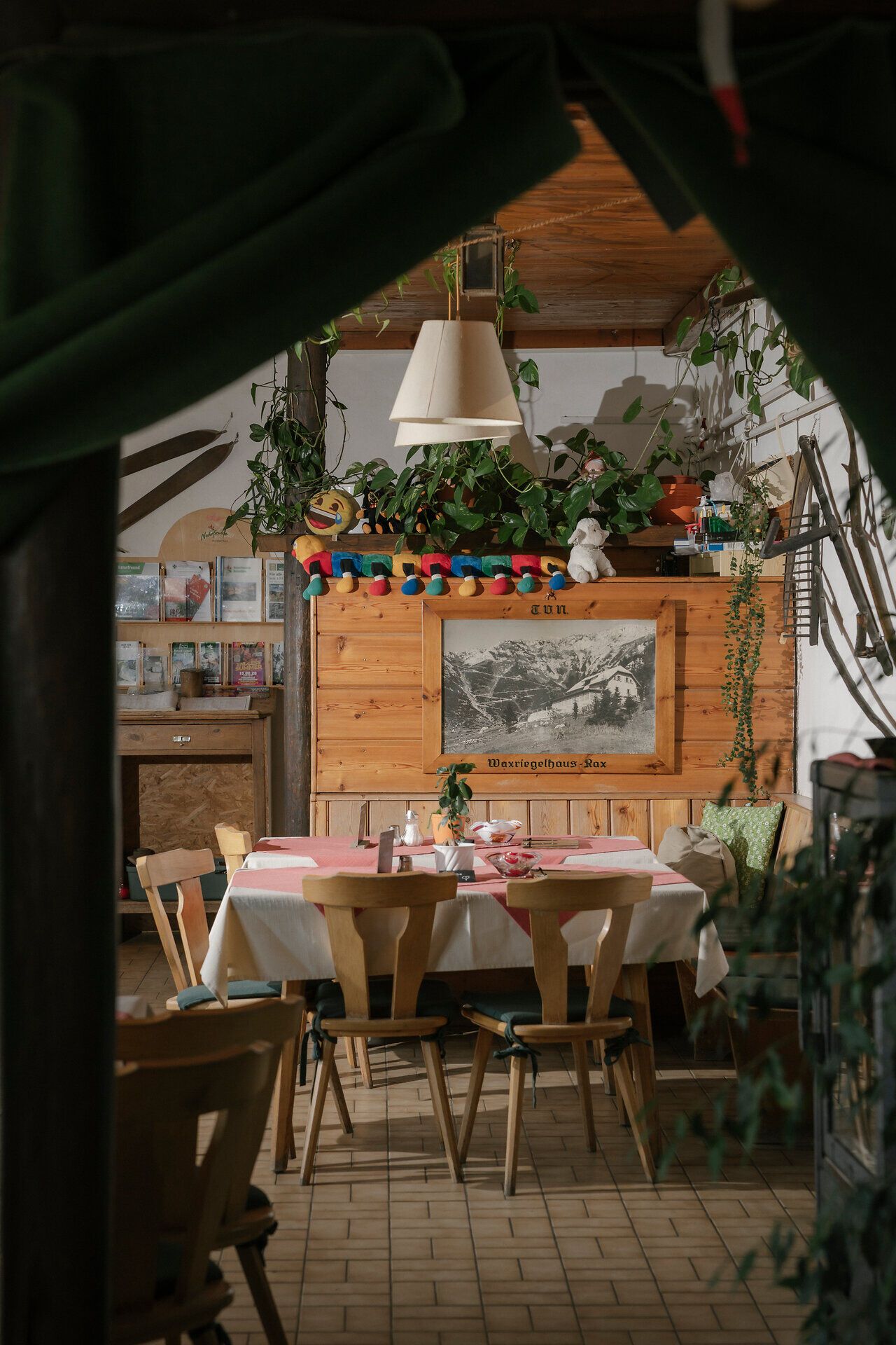 The cozy dining room at the Waxriegelhaus on the Rax, featuring wooden tables, plants, and tasteful décor