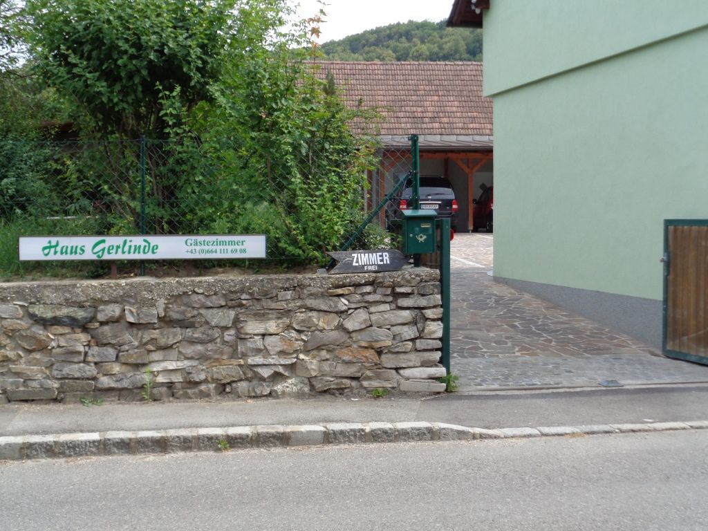 Entrance to Haus Gerlinde with sign and stone wall.