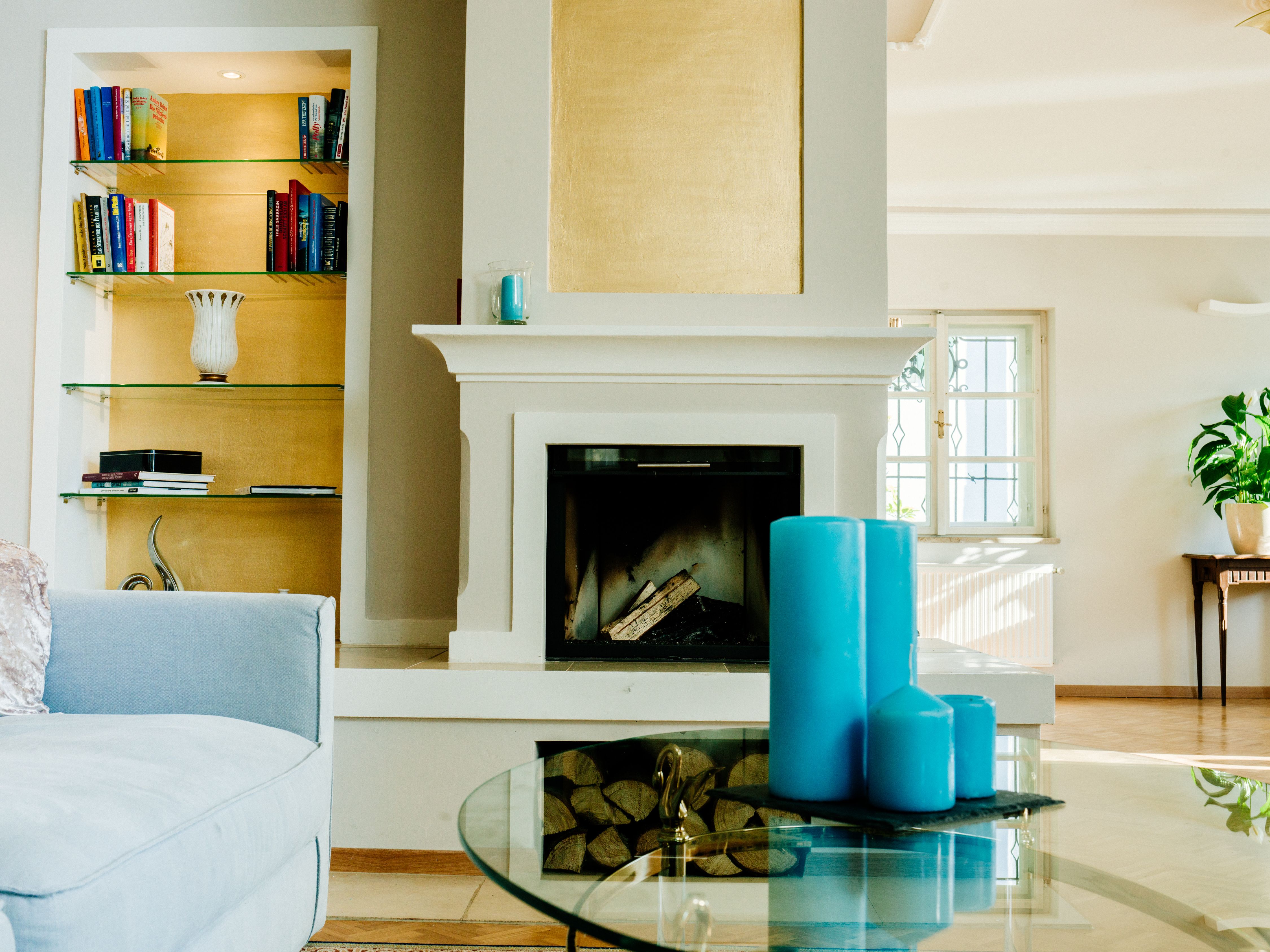 Living room with fireplace, blue candles and bookshelf.