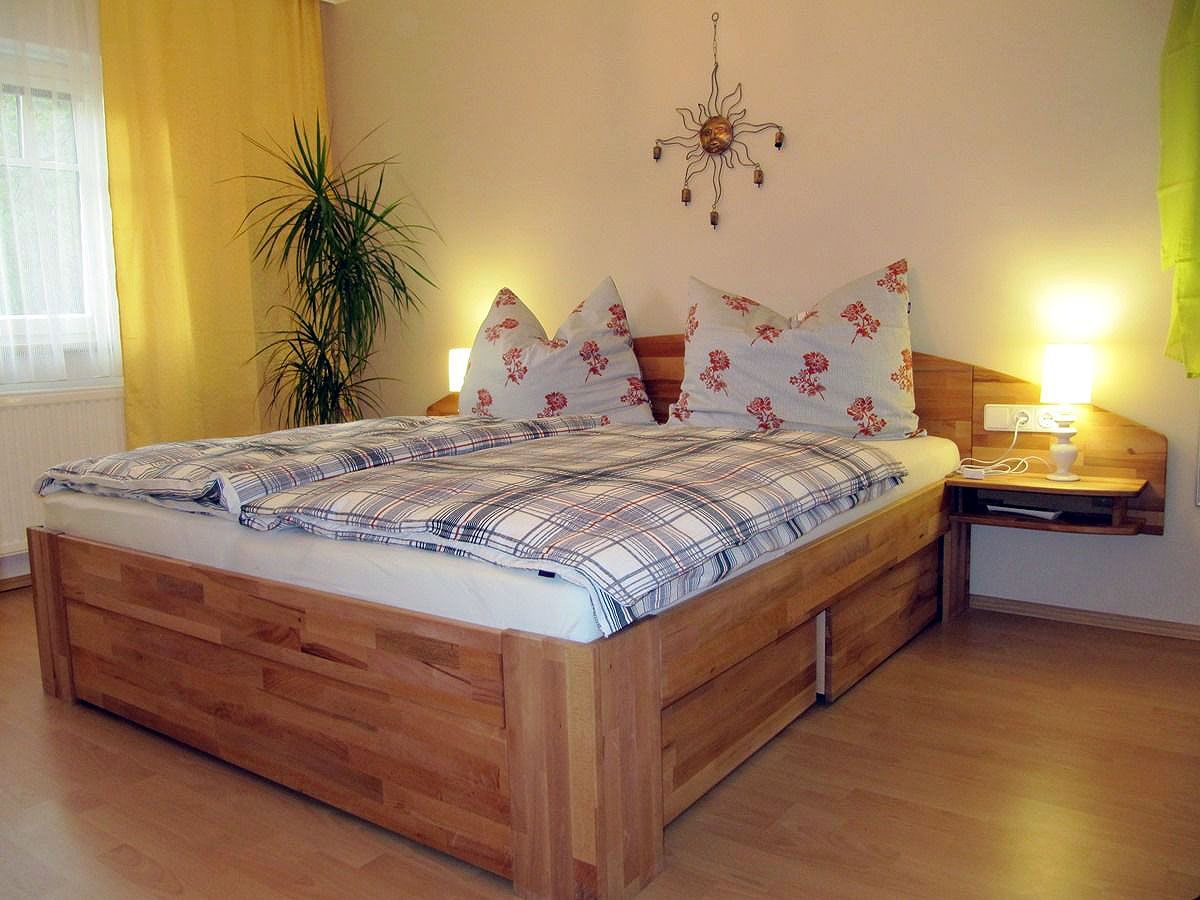 Cozy bedroom with double bed, plants and wall decoration.