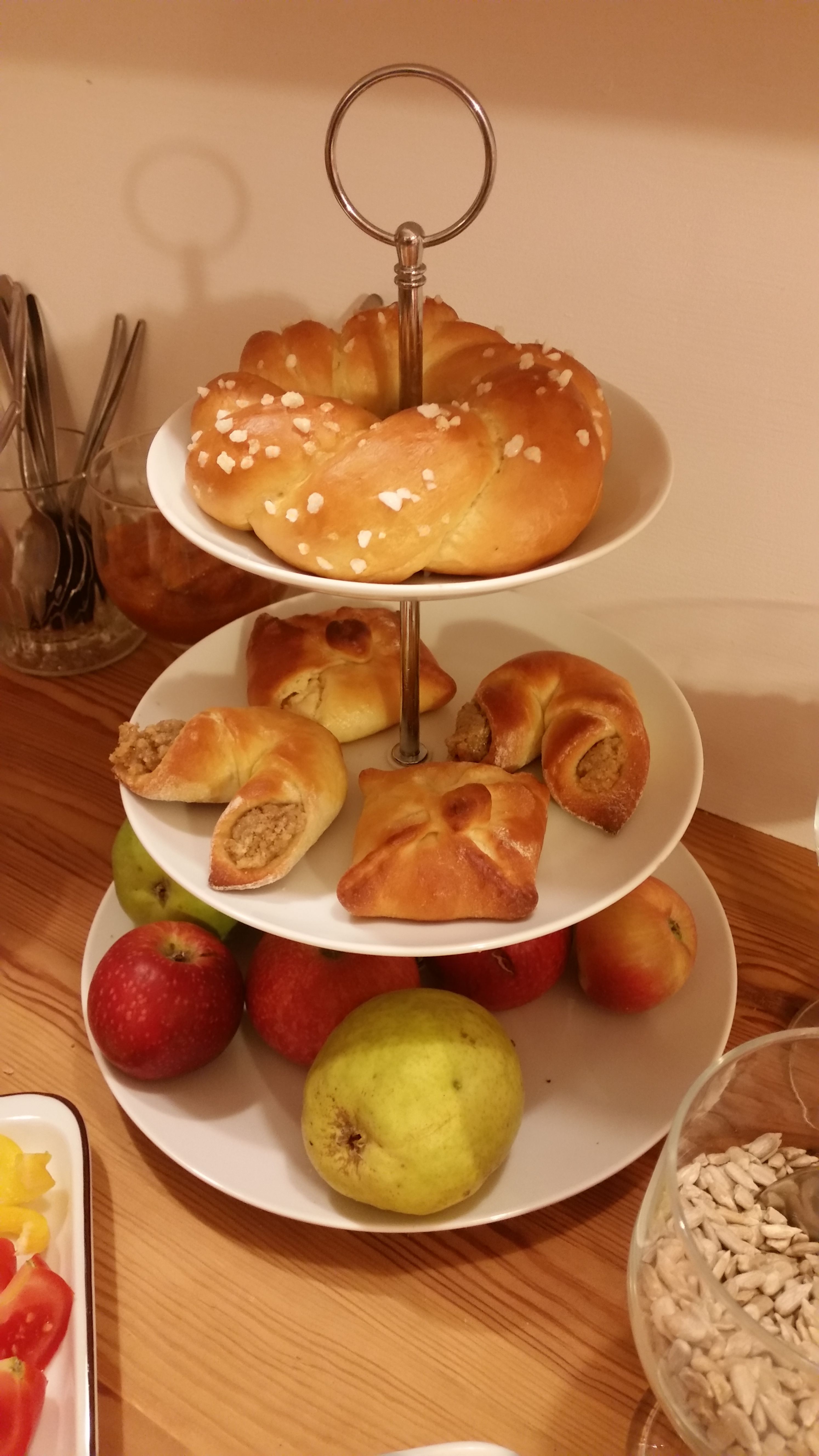 A three-tiered serving stand with pastries and fruit.