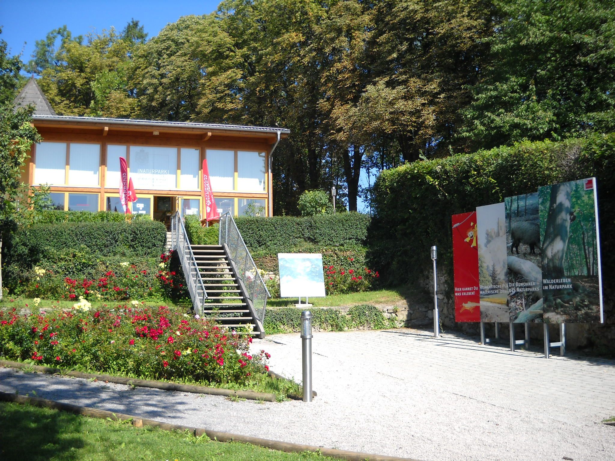 Entrance to Sparbach Nature Park with steps, flowerbeds and information boards.
