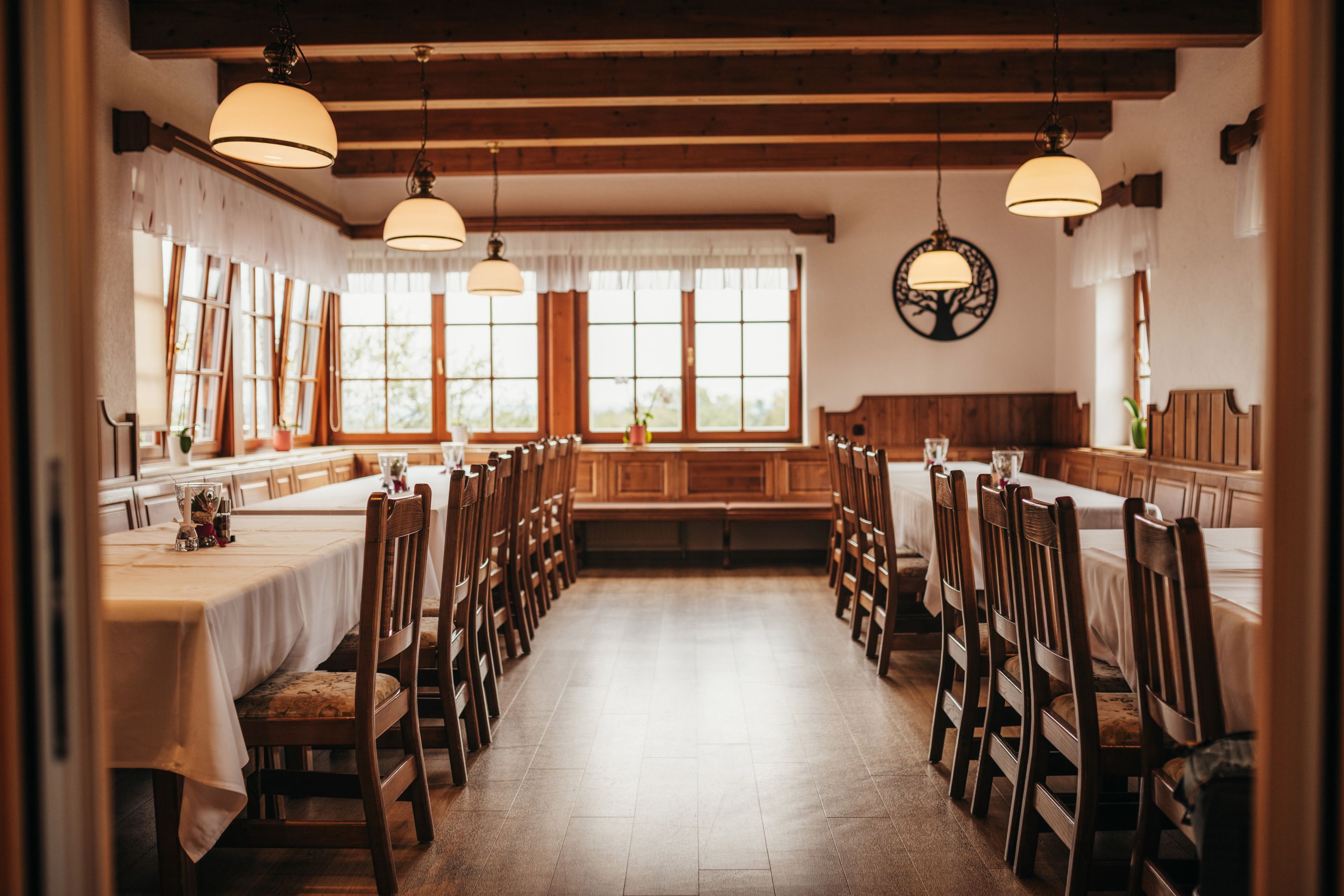 Cozy dining room with wooden furniture and large windows.