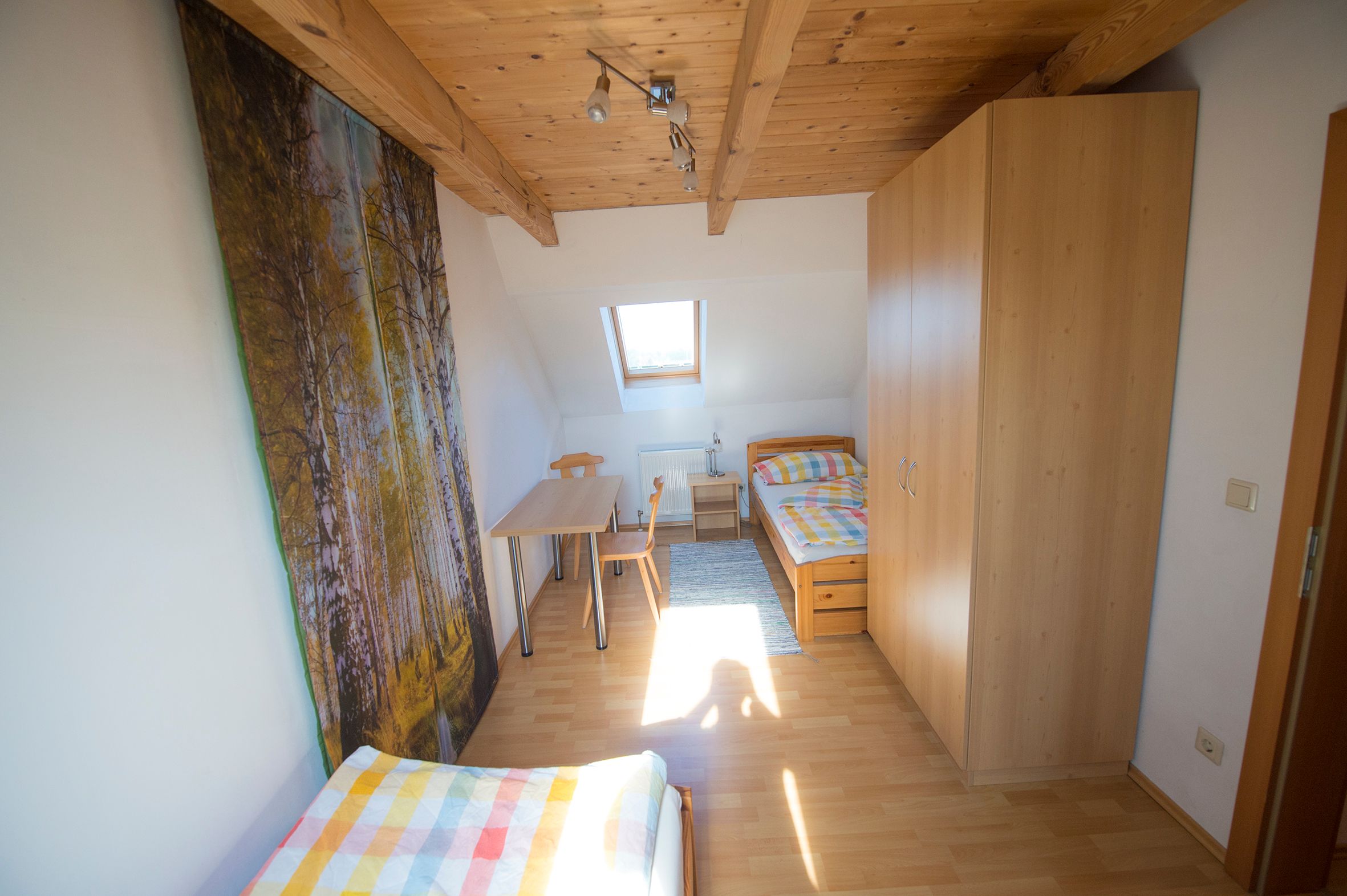 Large room with two single beds, small table, one window