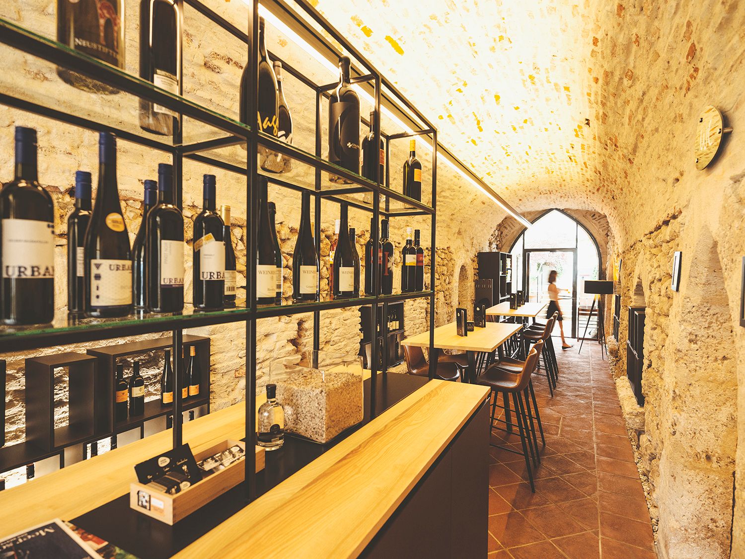 Wine cellar with bottle racks and tables in a vault.