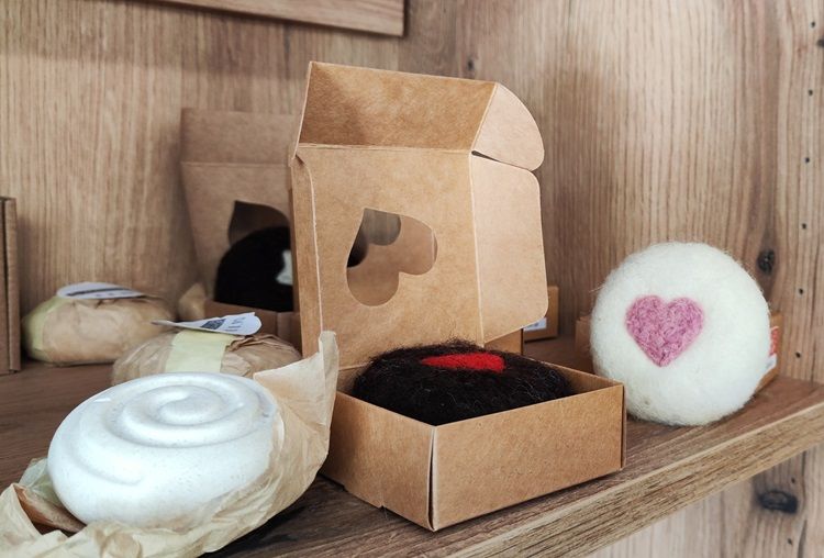 Handmade soaps and decorations with heart motifs on a shelf.