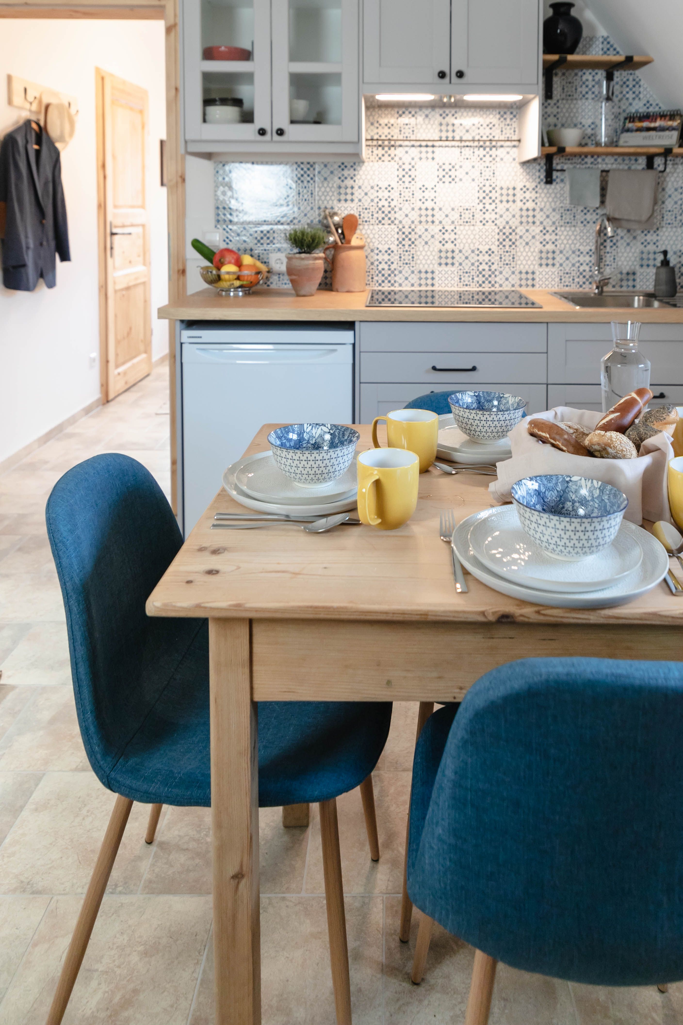 Breakfast table in a modern kitchen with blue and white bowls and yellow cups.