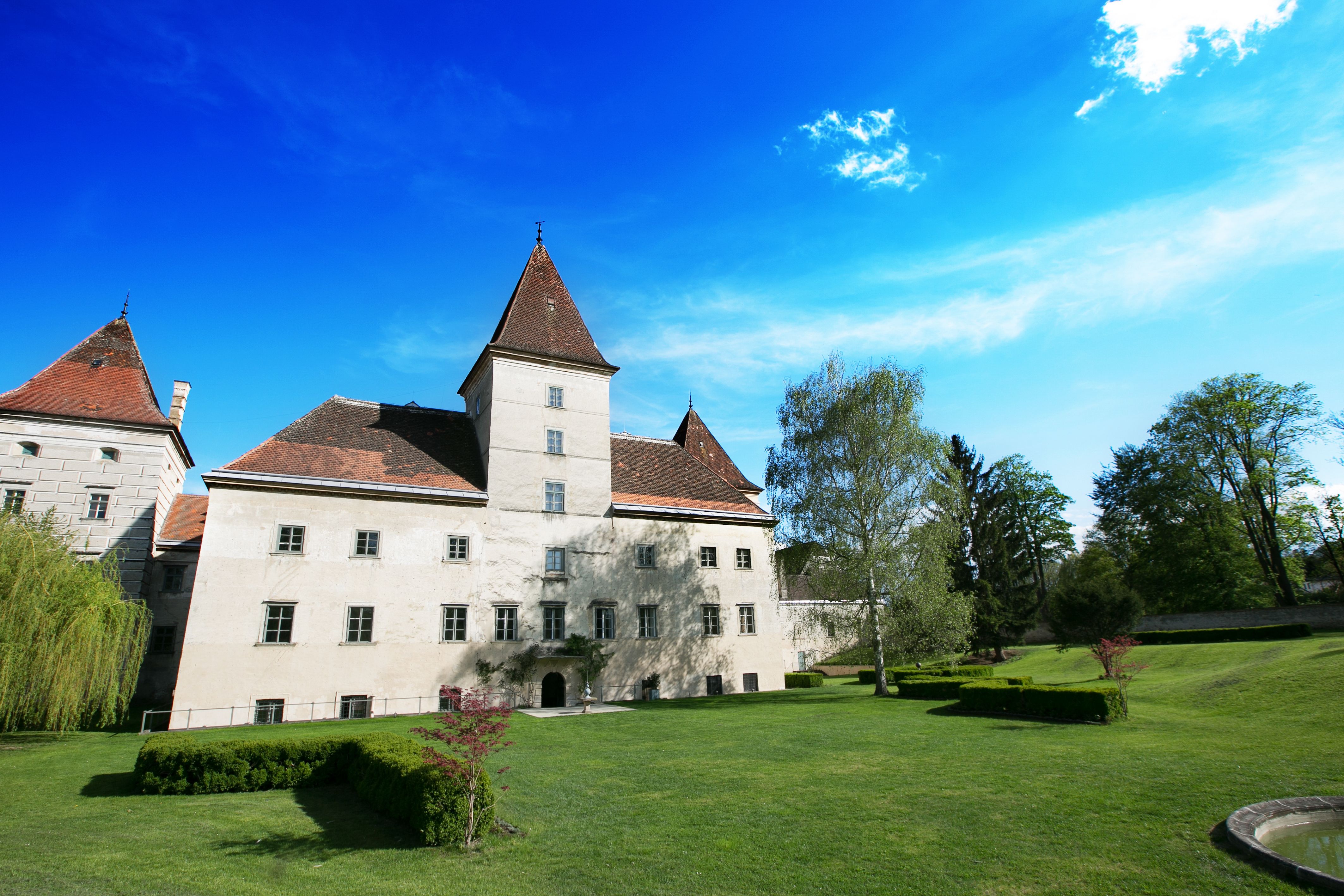 Walpersdorf Castle with garden and blue sky.