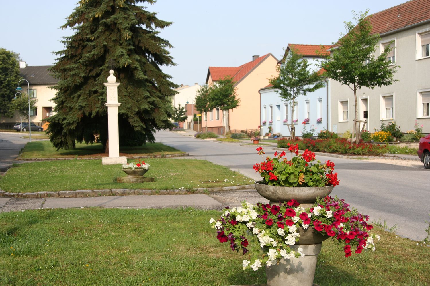 Street in Sierndorf with colorful flowers and houses.