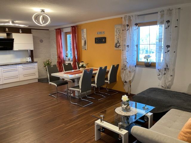 Modern eat-in kitchen with dining table, chairs, sofa and kitchenette.