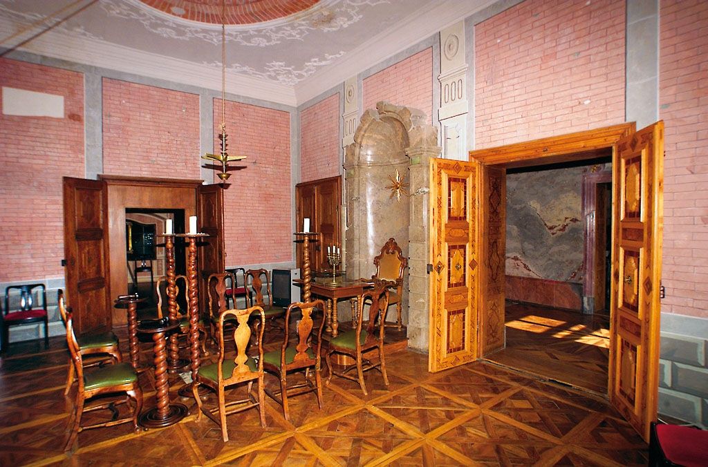 Interior of the Rosenau Castle Masonic Museum with wooden furniture and decorative walls.