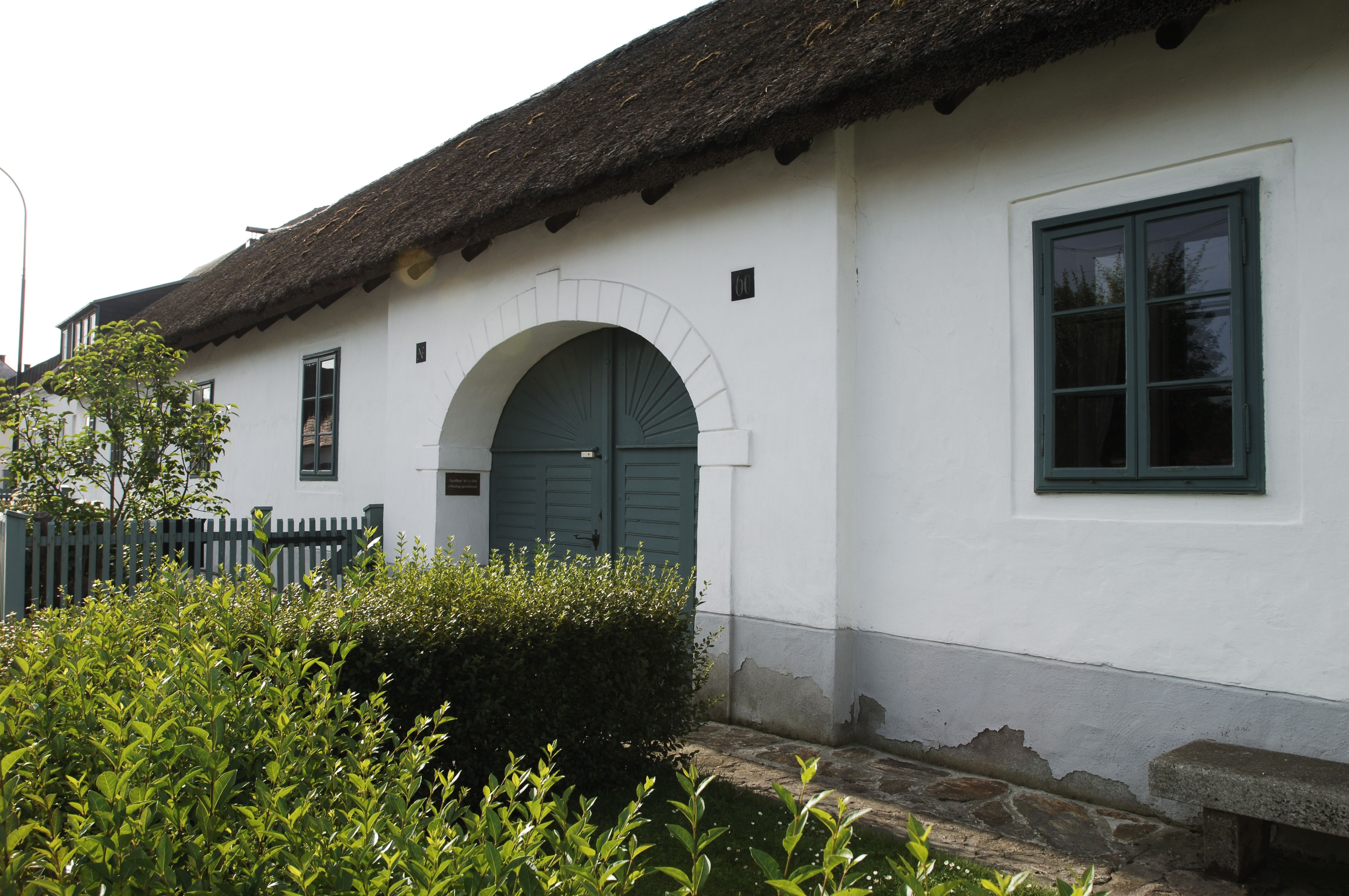 The house where Joseph Haydn was born in Rohrau, a white building with a thatched roof and green door.