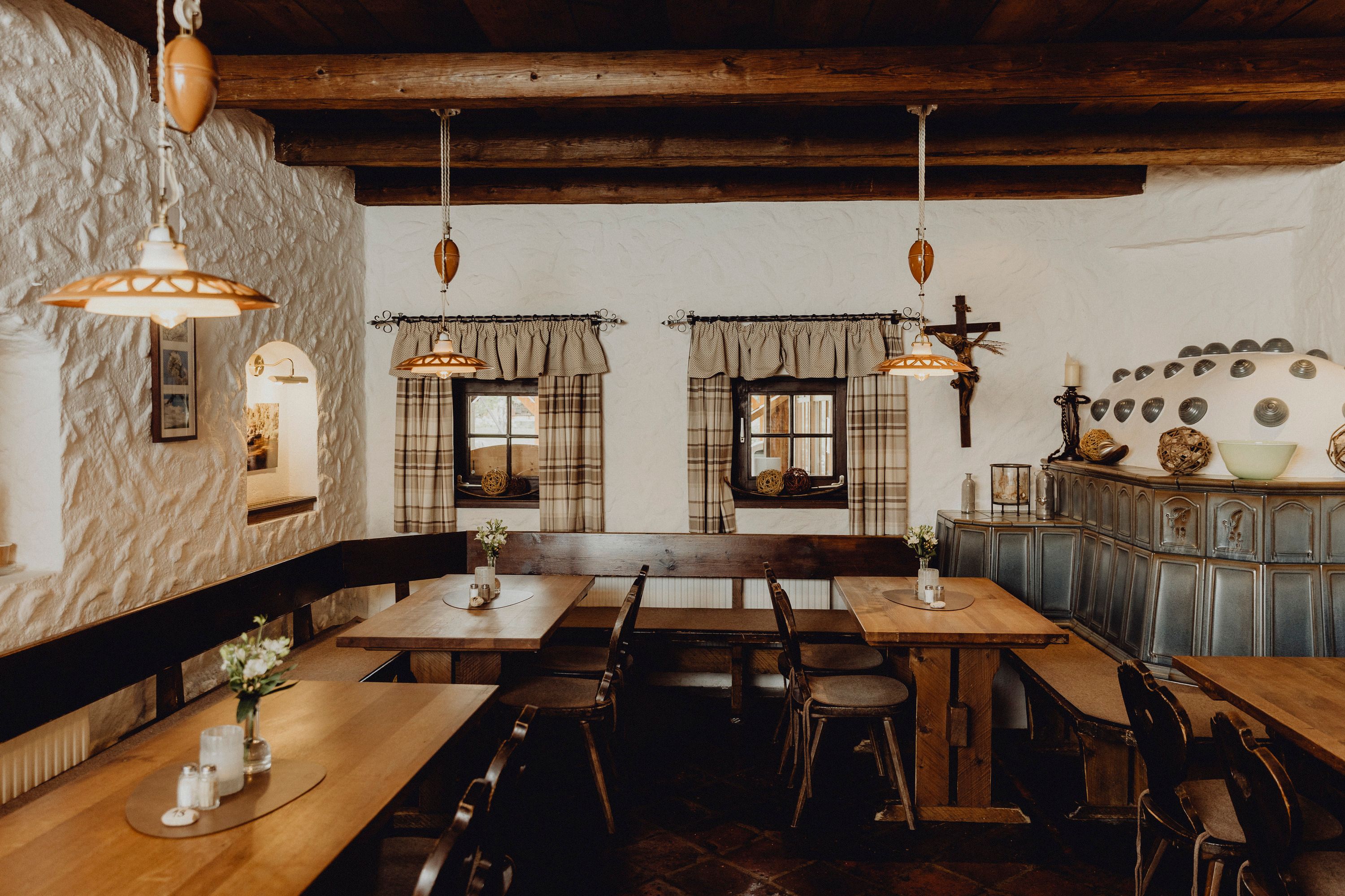 Cozy parlor with wooden furniture, tiled stove and rustic decoration.