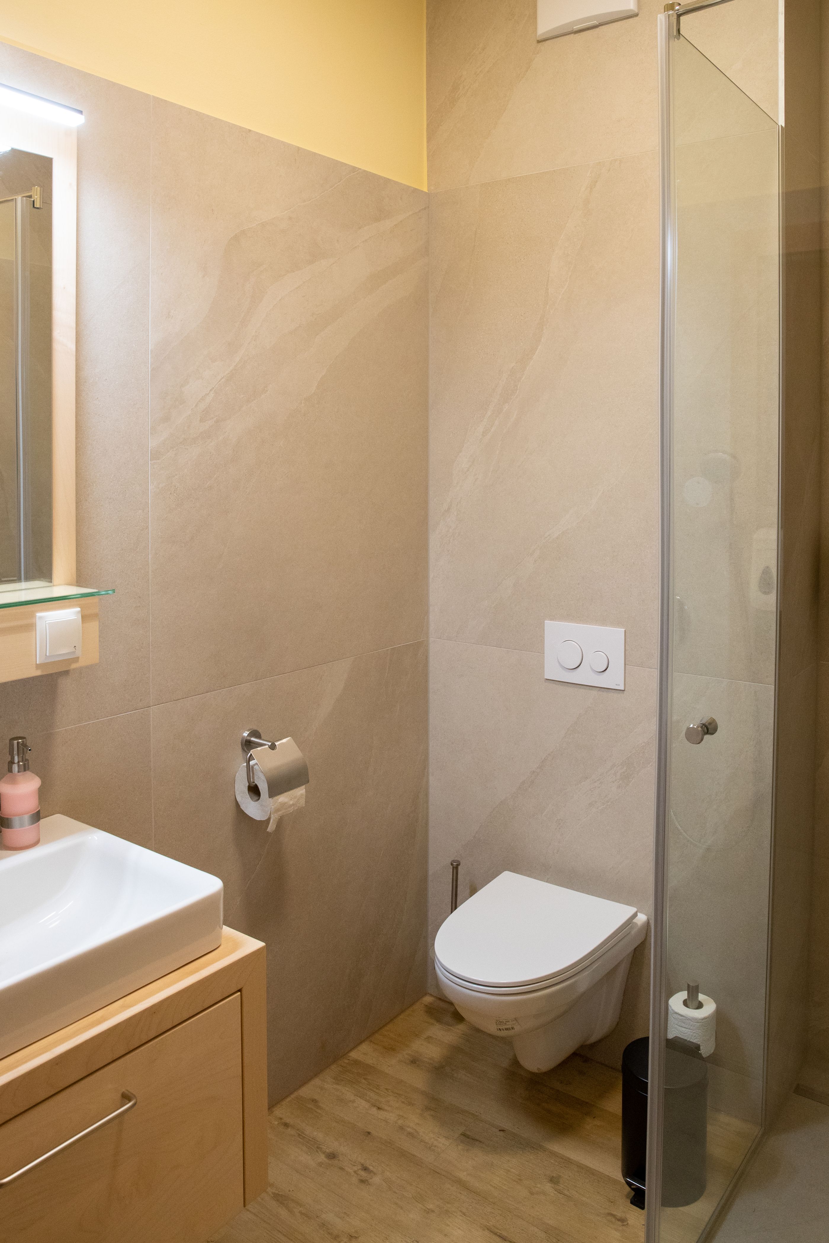 Modern bathroom with washbasin, toilet and shower cubicle.