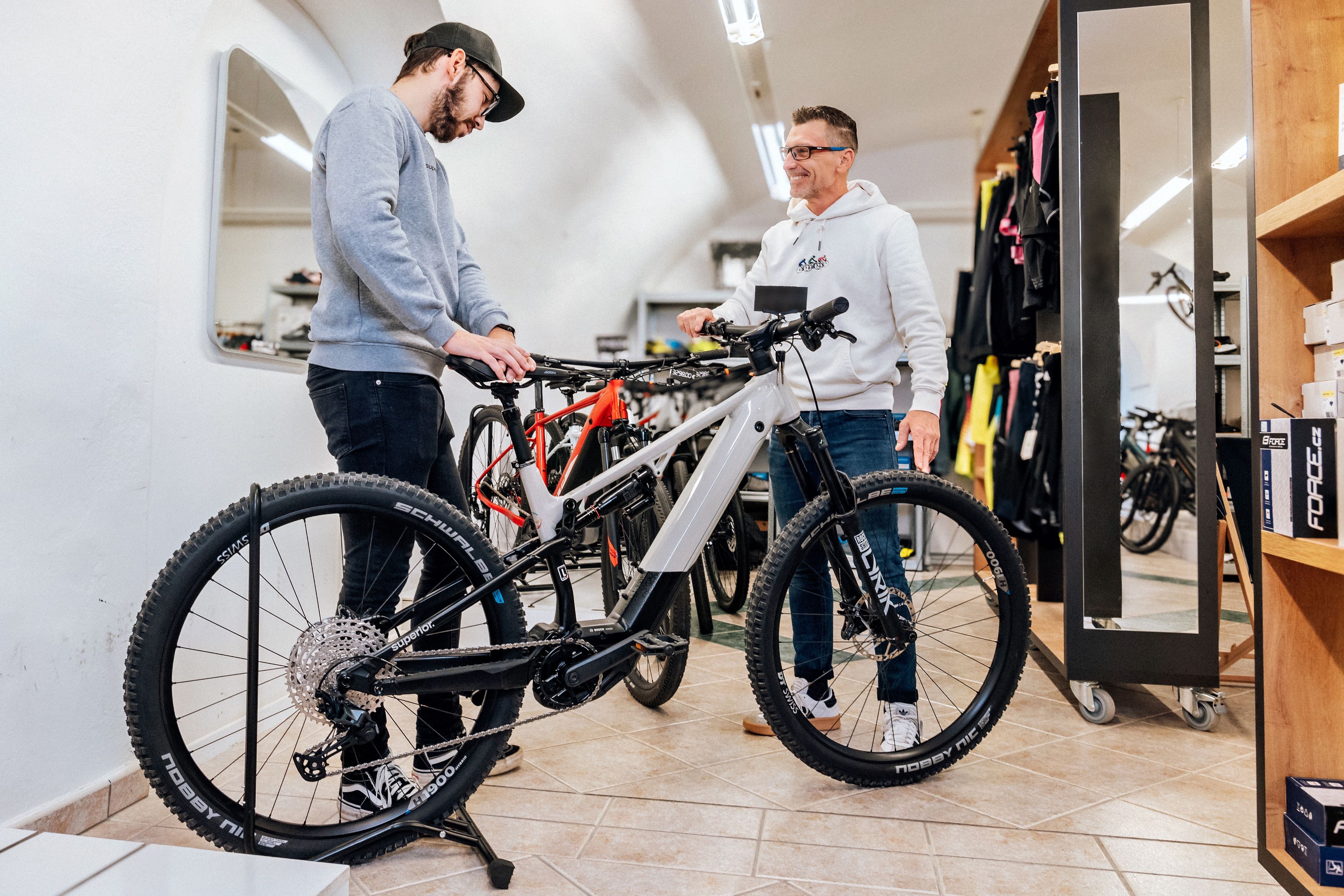 Two men look at a bicycle in a bicycle store.