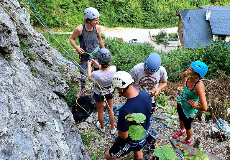 Group of people climbing outdoors with helmets and climbing equipment.