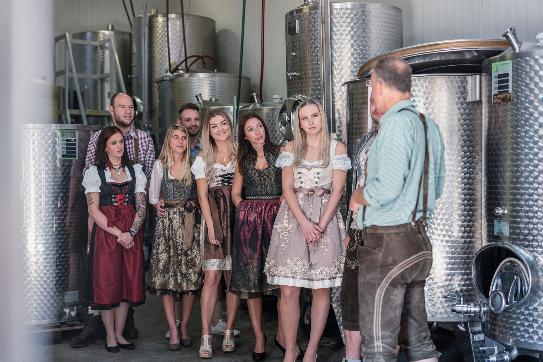 Group of people in traditional dress in a brewery.