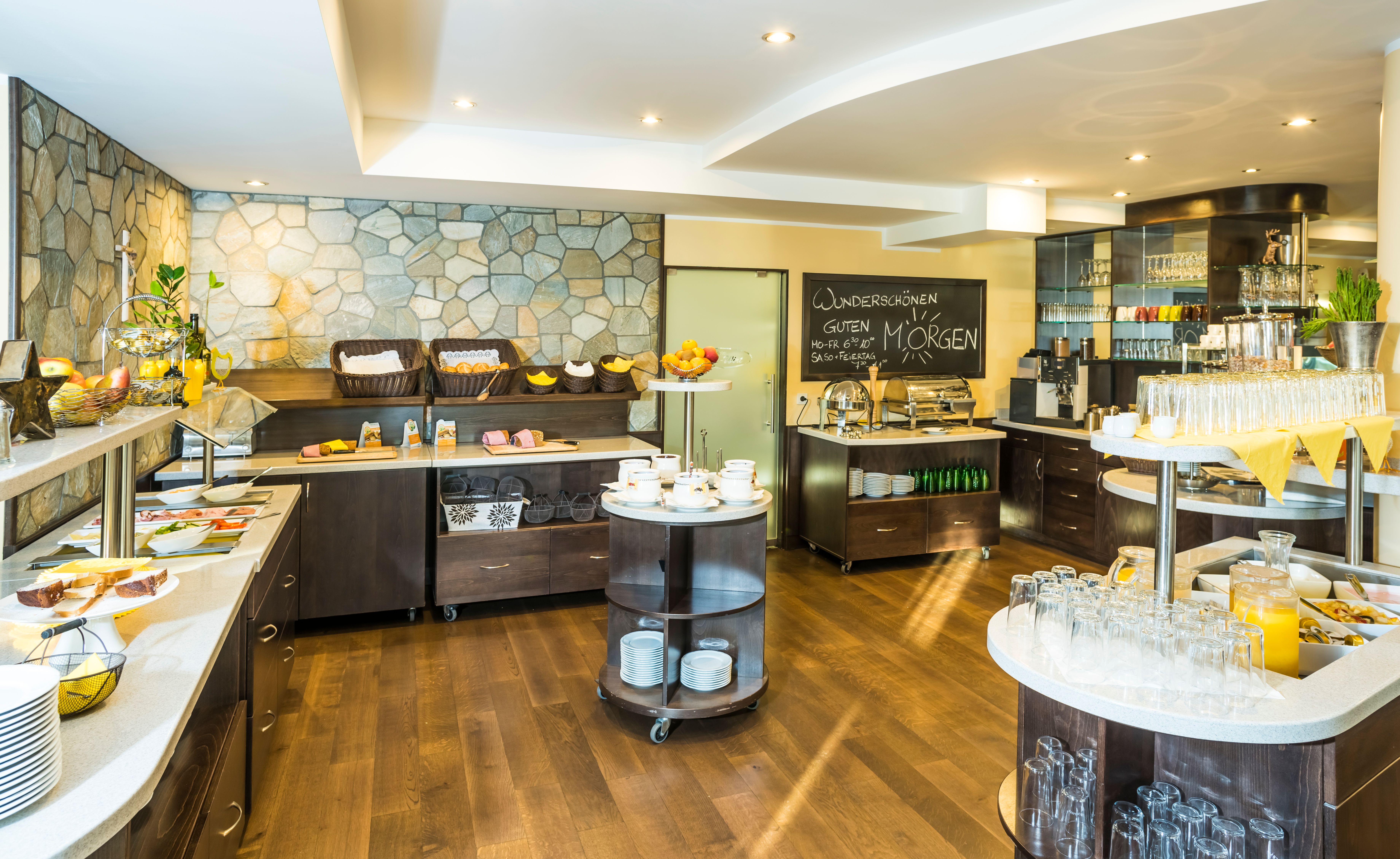 A breakfast buffet with a variety of food and drinks in a bright room.